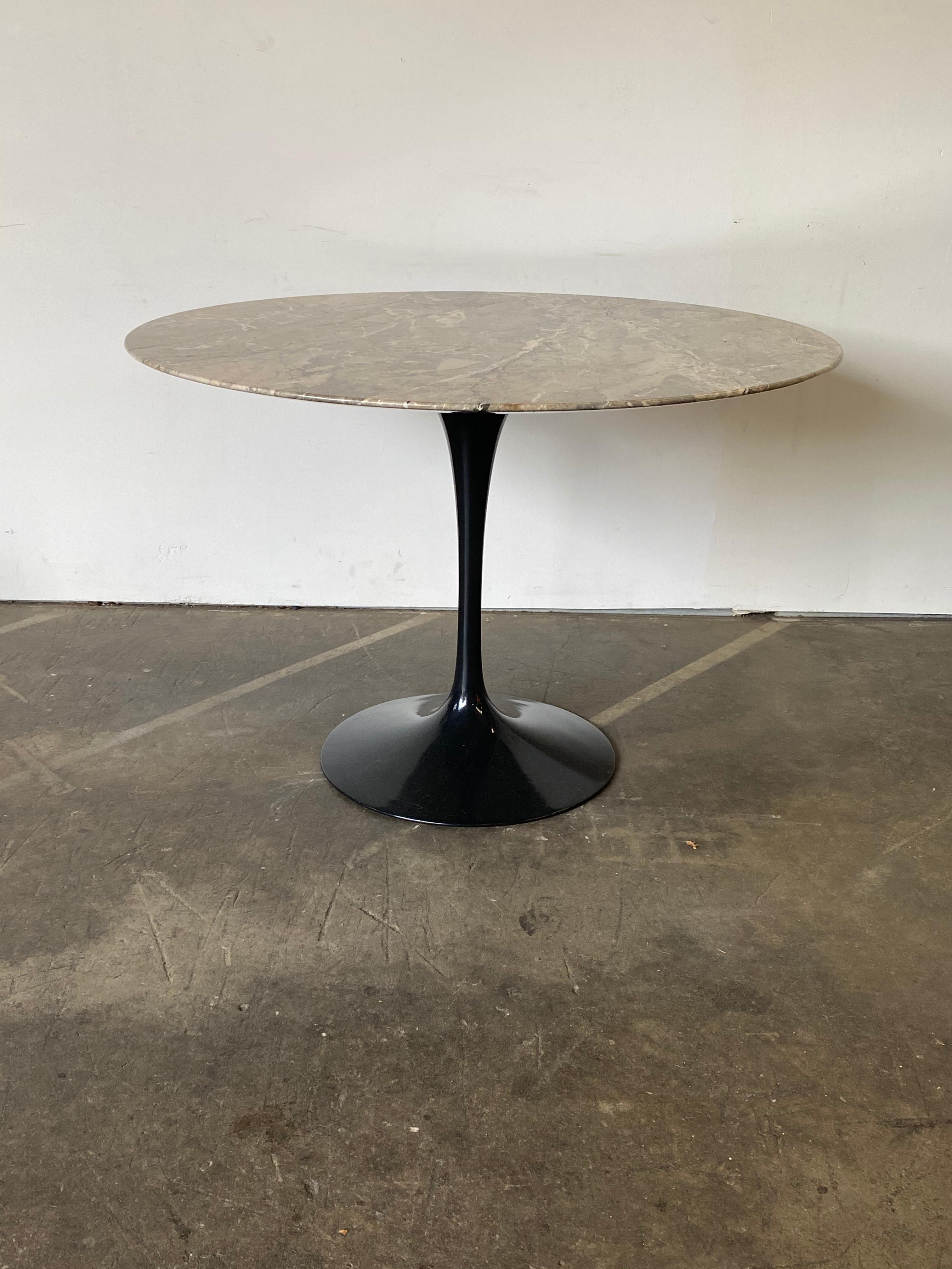 Circular dining table with 42” diameter marble top. Designed by Eero Saarinen for Knoll. Signed and guaranteed authentic. Gorgeous vein pattern and colors with classic Knoll knife edge slab atop cast aluminum powder coated base.