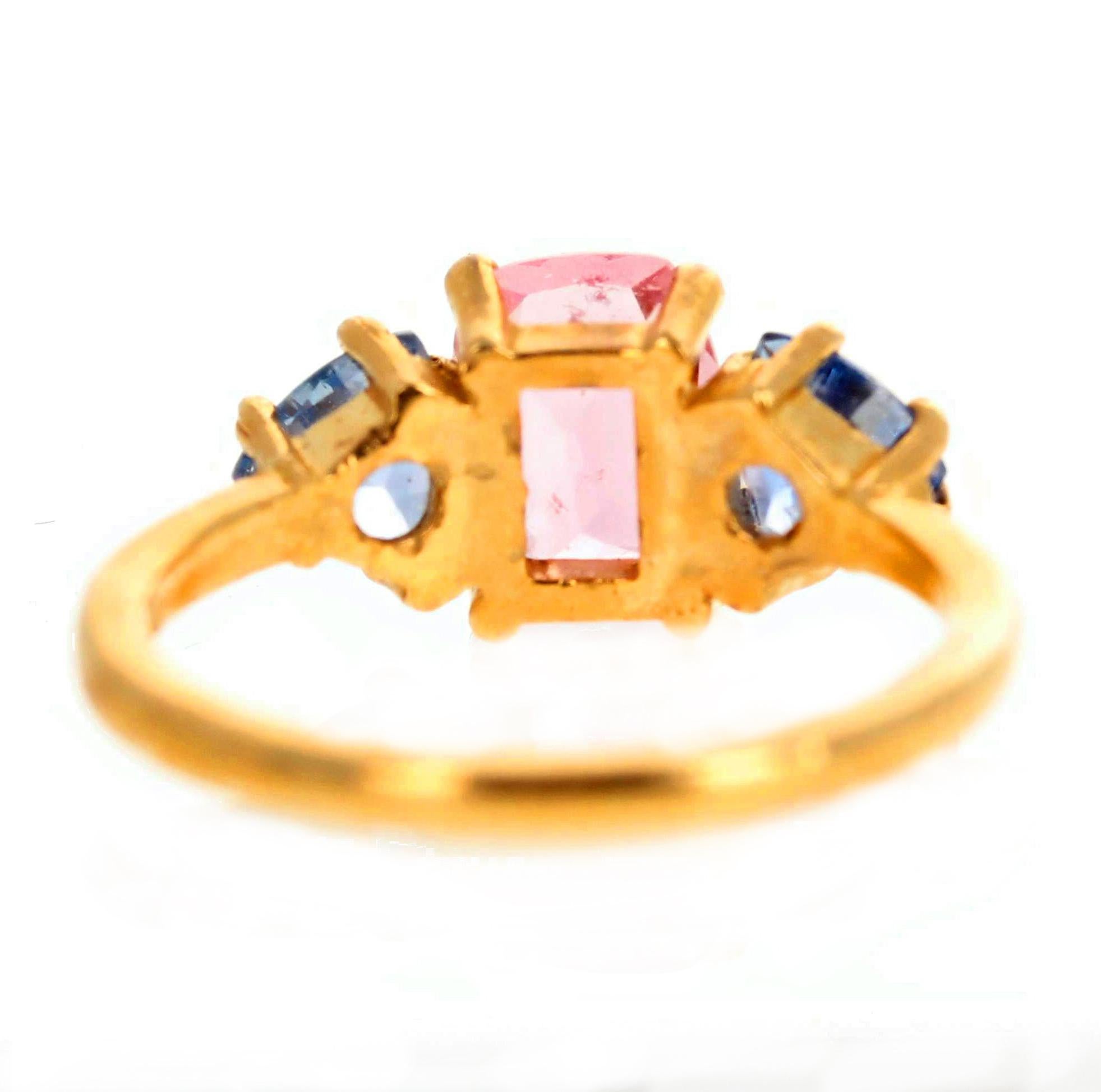 Gorgeous Sri Lankan pink Tourmaline - 1.35 Carats - 8 mm x 6 mm approximately - enhanced with two matching sparkling blue Sapphire trillions set in this lovely 14K yellow gold ring size 7 sizable. 