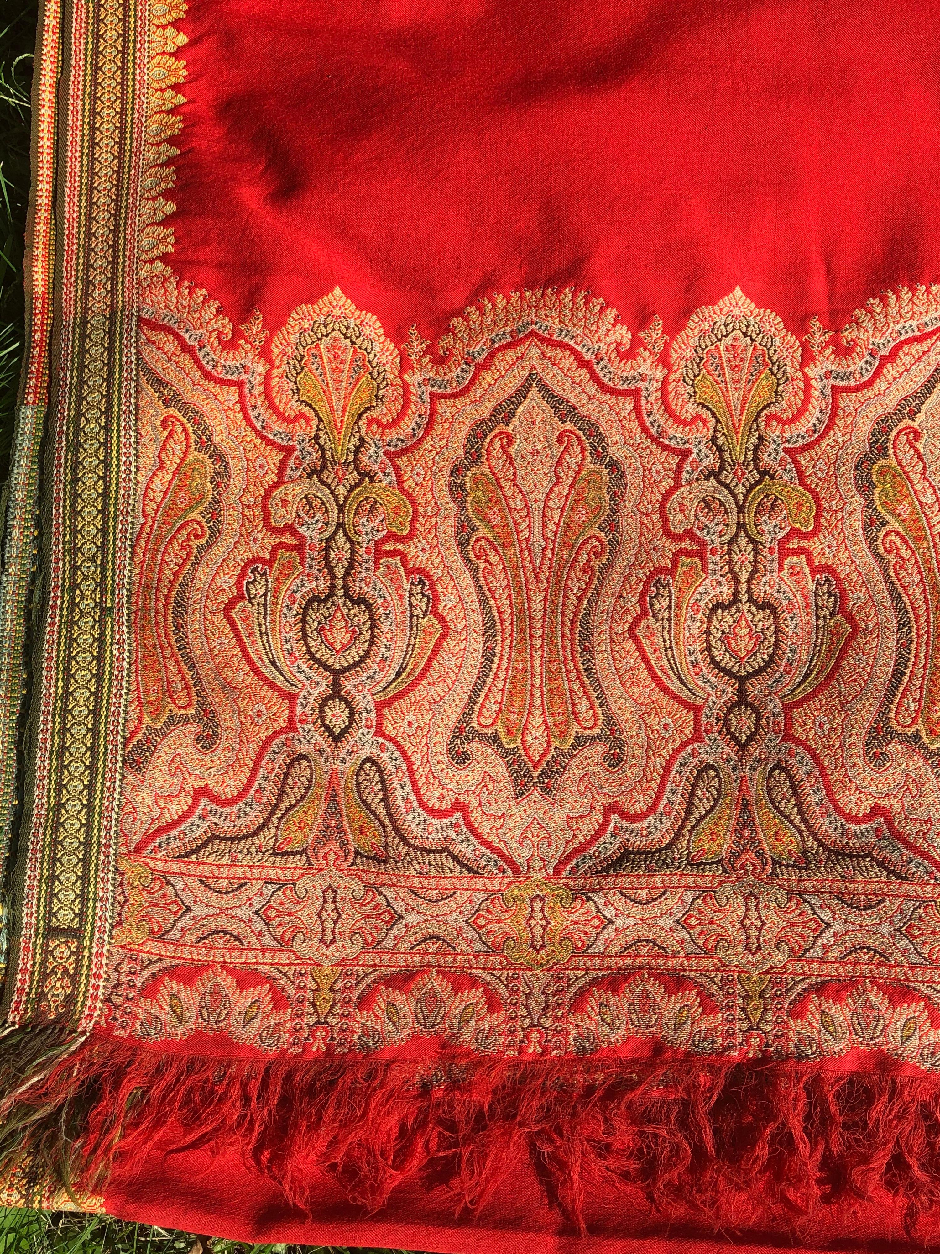 Brilliant tomato red finely woven wool Kashmiri throw or shawl
with beautiful paisley borders. Predominantly red wool with red, yellow and
green embroidered borders at the base and along the sides. Very large
size throw. Few very small holes and