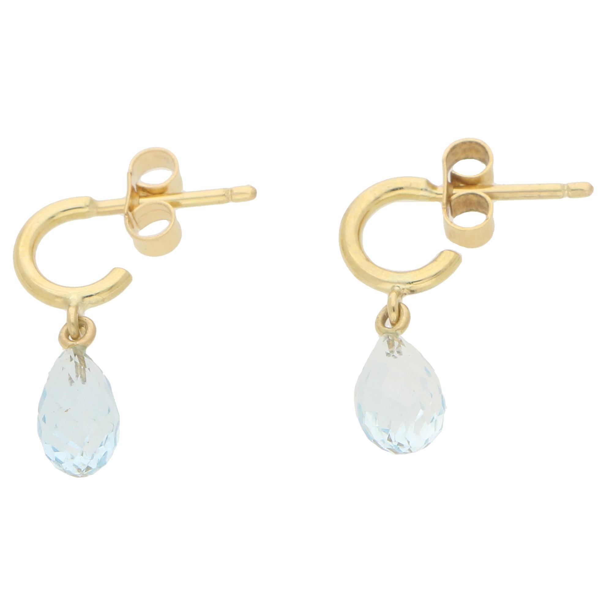 A stunning pair of briolette aquamarine half hoop earrings set in 18k yellow gold. Each earring features a singular briolette cut aquamarine which hangs elegantly from a simple solid half hoop earring which have posts and butterfly fittings.

Due to