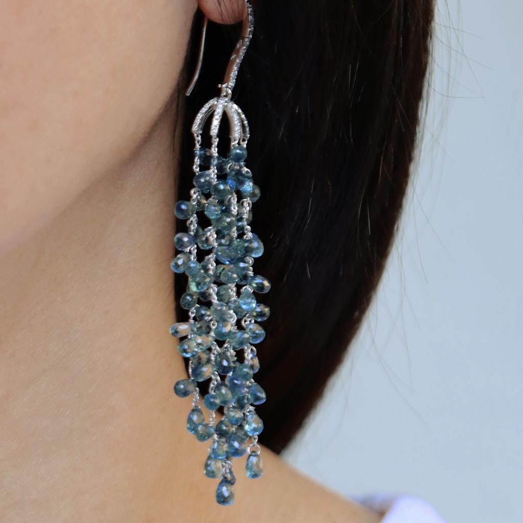 A beautiful pair of 18K white gold long Tassel Earrings set with Blue Briolette-cut Sapphires and pave set Diamonds.  
A matching ring is available.

The Sapphires graduate in color from light blue to dark blue.
When you wear the earrings, the color