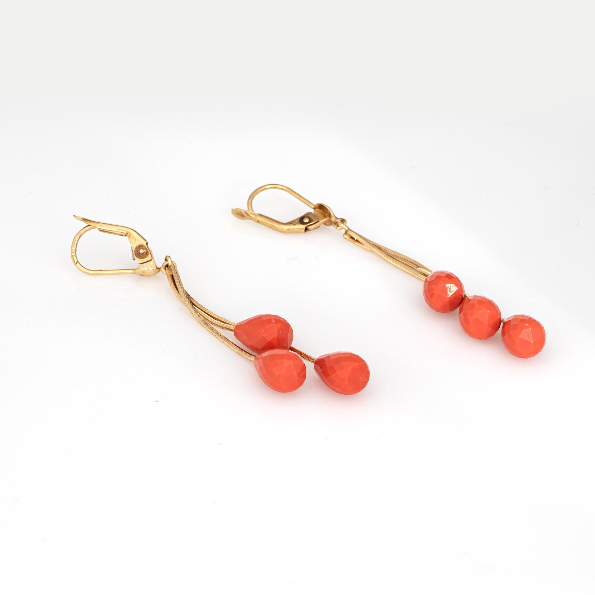 Stylish coral drop earrings crafted in 14k yellow  (circa 1980s).

Briolette faceted coral measures 9mm x 6.5mm. The coral is in very good condition and free of cracks or chips.    

The elegant three-tiered drops measure 2 1/2 inches in length and