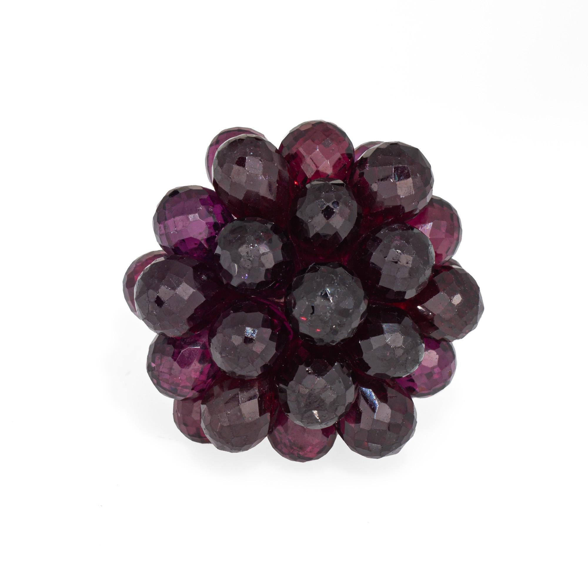Bold & distinct cocktail ring, crafted in 18 karat white gold. 

Briolette faceted garnets measure approx. 5mm. The garnets are in very good condition with some light surface abrasions visible under a 10x loupe). 

The bold ring highlights a