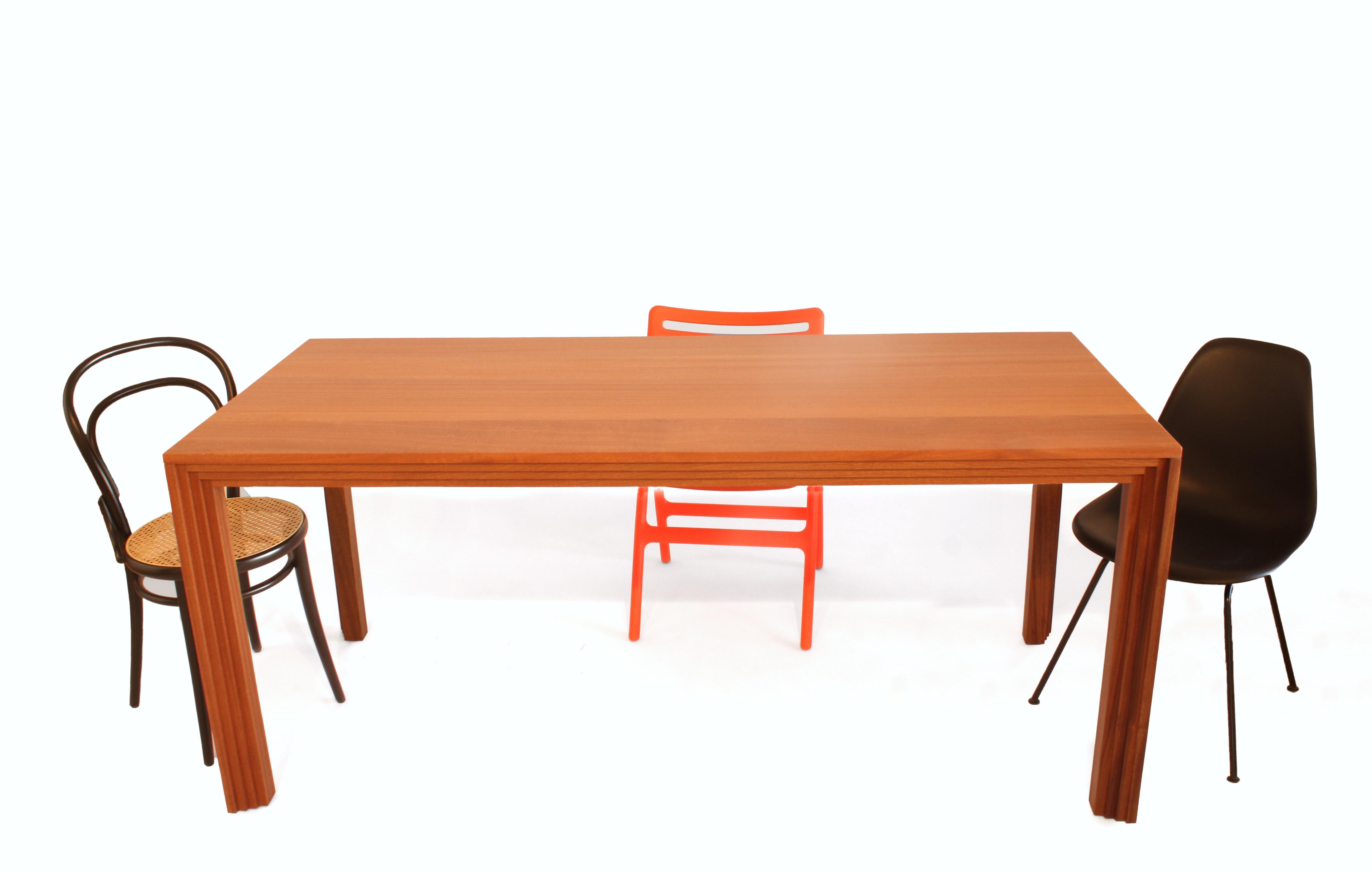 Il tavolo da pranzo Brion è realizzato dal designer e produttore americano Greg Palombo. Si tratta di un tavolo in legno massiccio realizzato con un legno rosso ricco e profondamente colorato chiamato sapele (simile al mogano). Il design e il nome