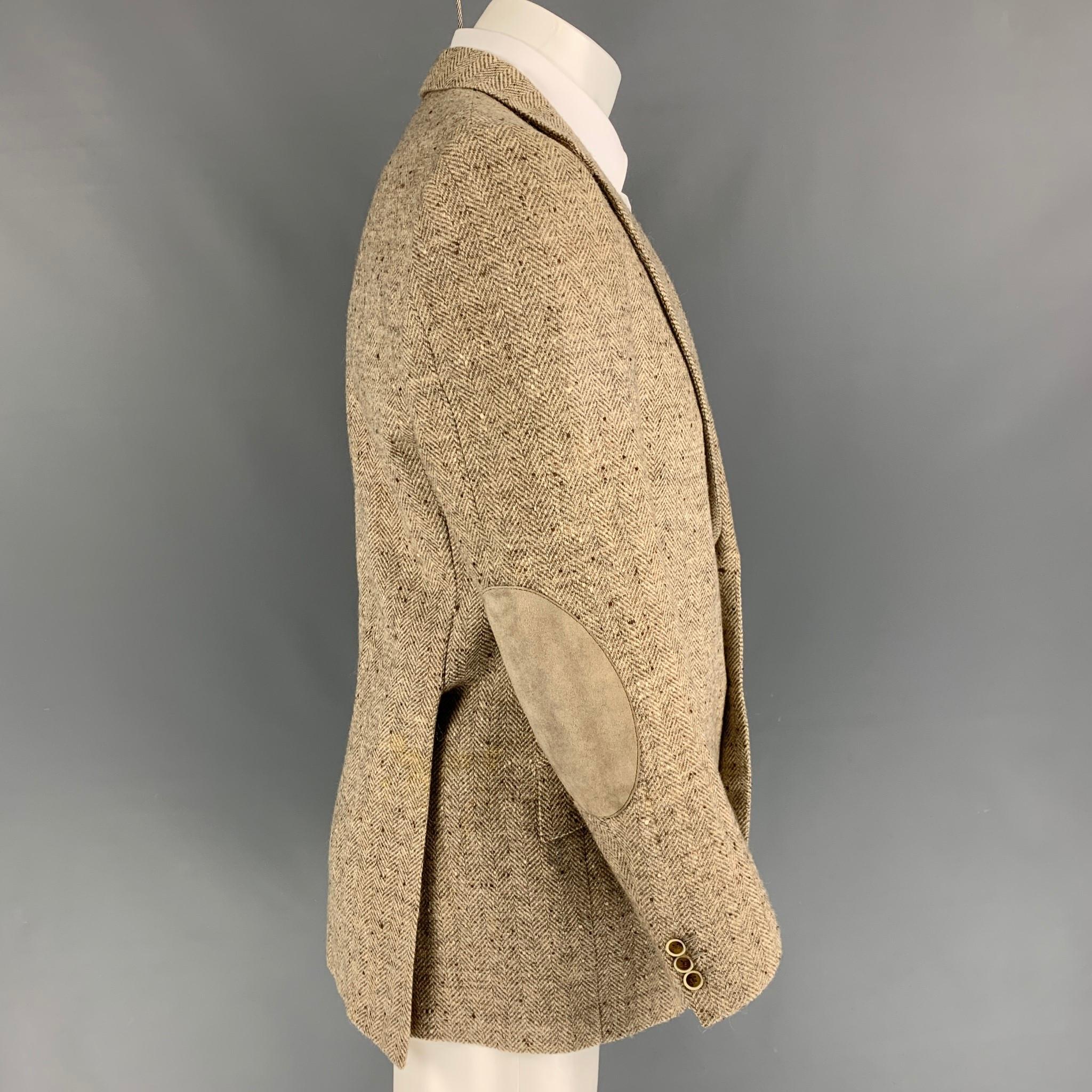 BRIONI for WILKES BASHFORD sport coat comes in a cream & taupe herringbone wool / alpaca with a full liner featuring a notch lapel, flap pockets, suede elbow patches, double back vent, and a double button closure. Made in Italy. 

Good Pre-Owned