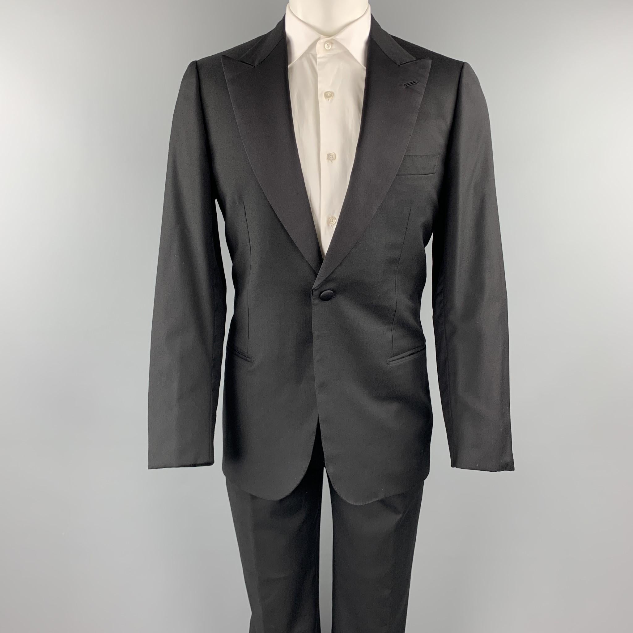 BRIONI for WILKES BASHFORD tuxedo suit comes in a black wool and includes a single breasted, single button sport coat with a peak lapel, monogram print liner, and matching pleated front trousers. Made in Italy.

Excellent Pre-Owned
