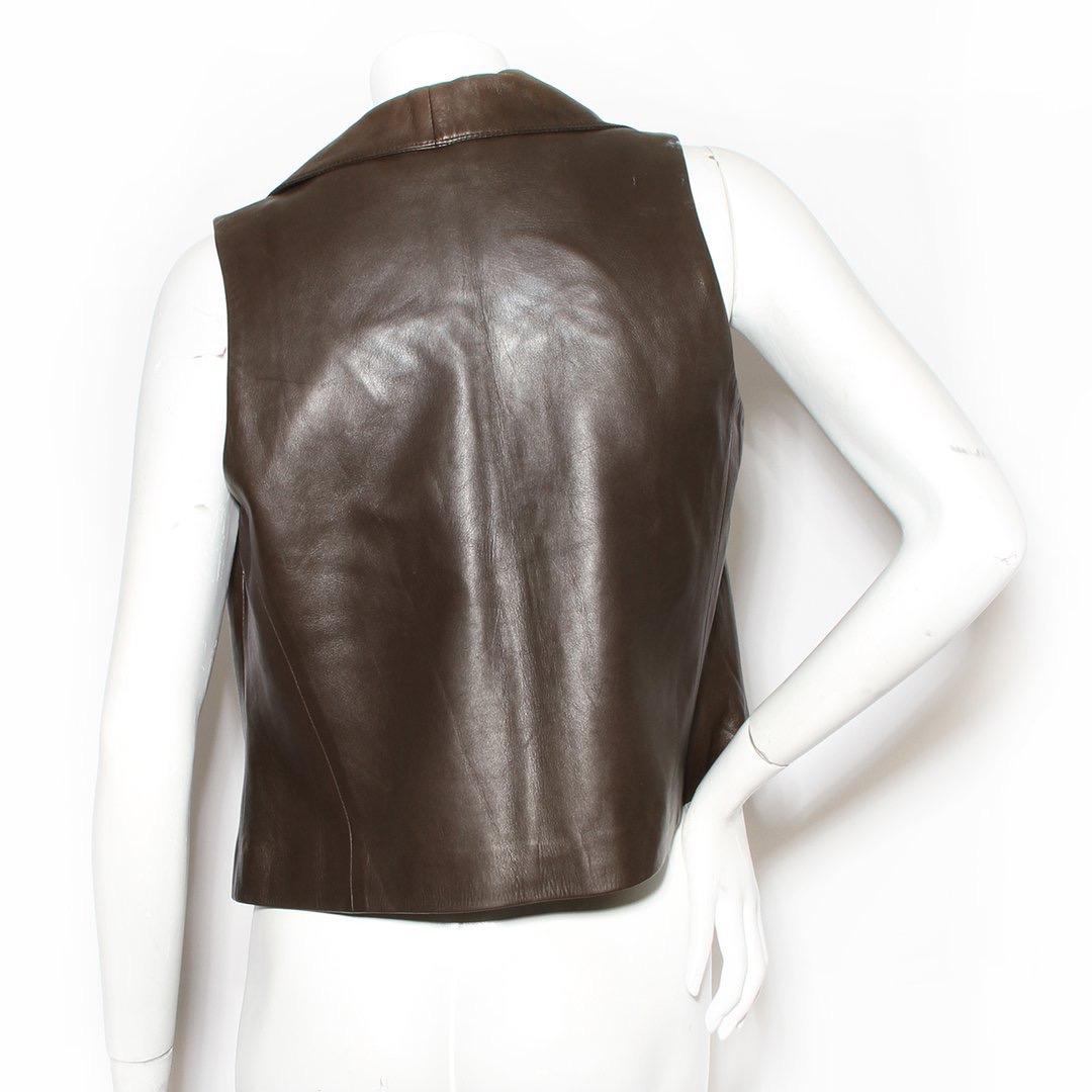 Leather Vest by Brioni 
Brown 
Lined silk interior with red detail 
Sleeveless 
Button-down front closure 
Deep V-neck 
No pockets
Condition: Good, slight weathering on the leather. Wear consistent with age and use. (see photos)  
Size/Measurements: