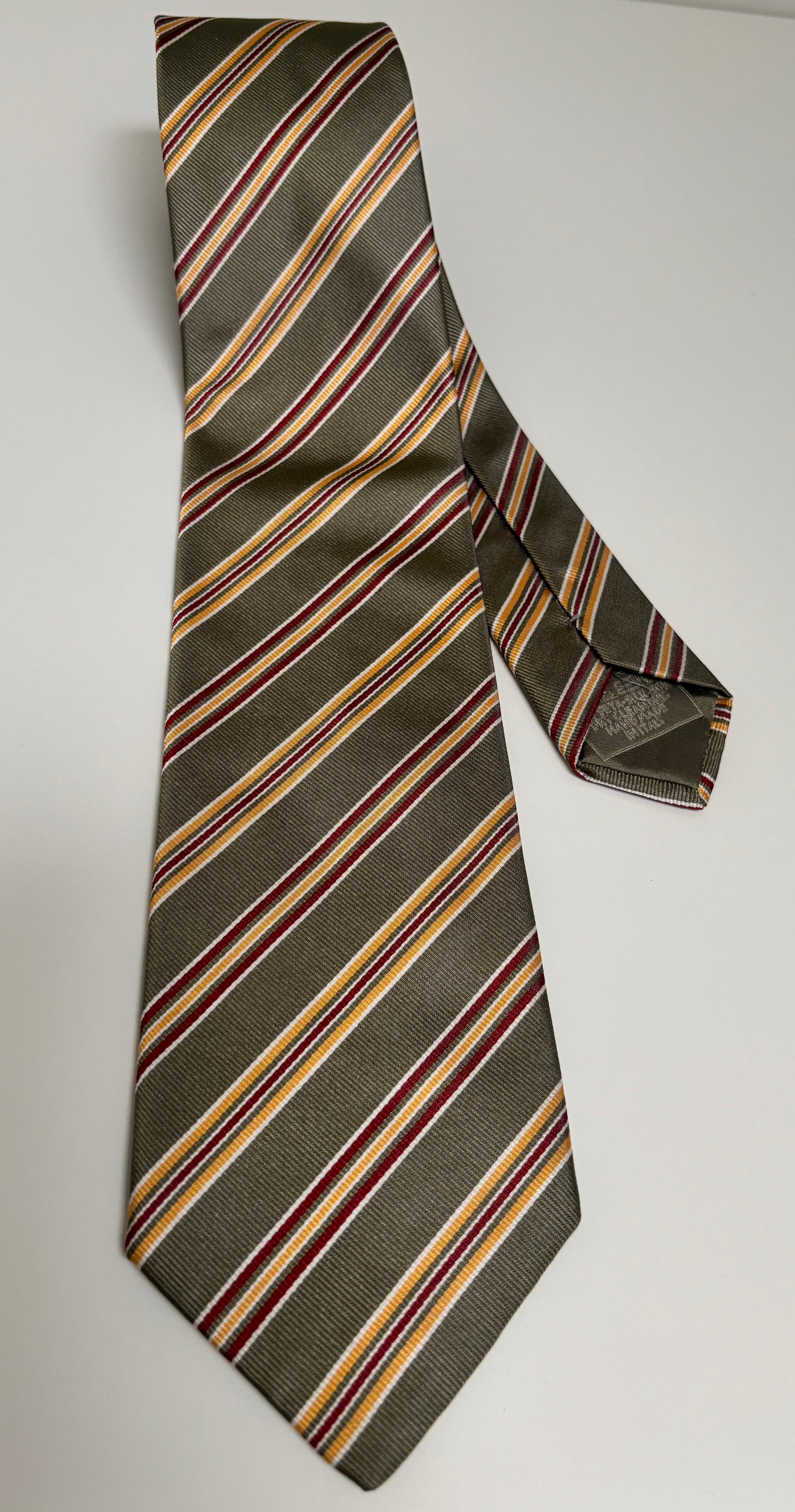 Cravate en soie bleue Brioni cravate homme.
Cravate Brioni en soie bleue de luxe, fabriquée à la main en Italie.
Cravate de luxe en soie conçue par Brioni. 
Cravate en soie rayée, présentant des rayures vertes/brunes, rouges/marrons, jaunes/or et