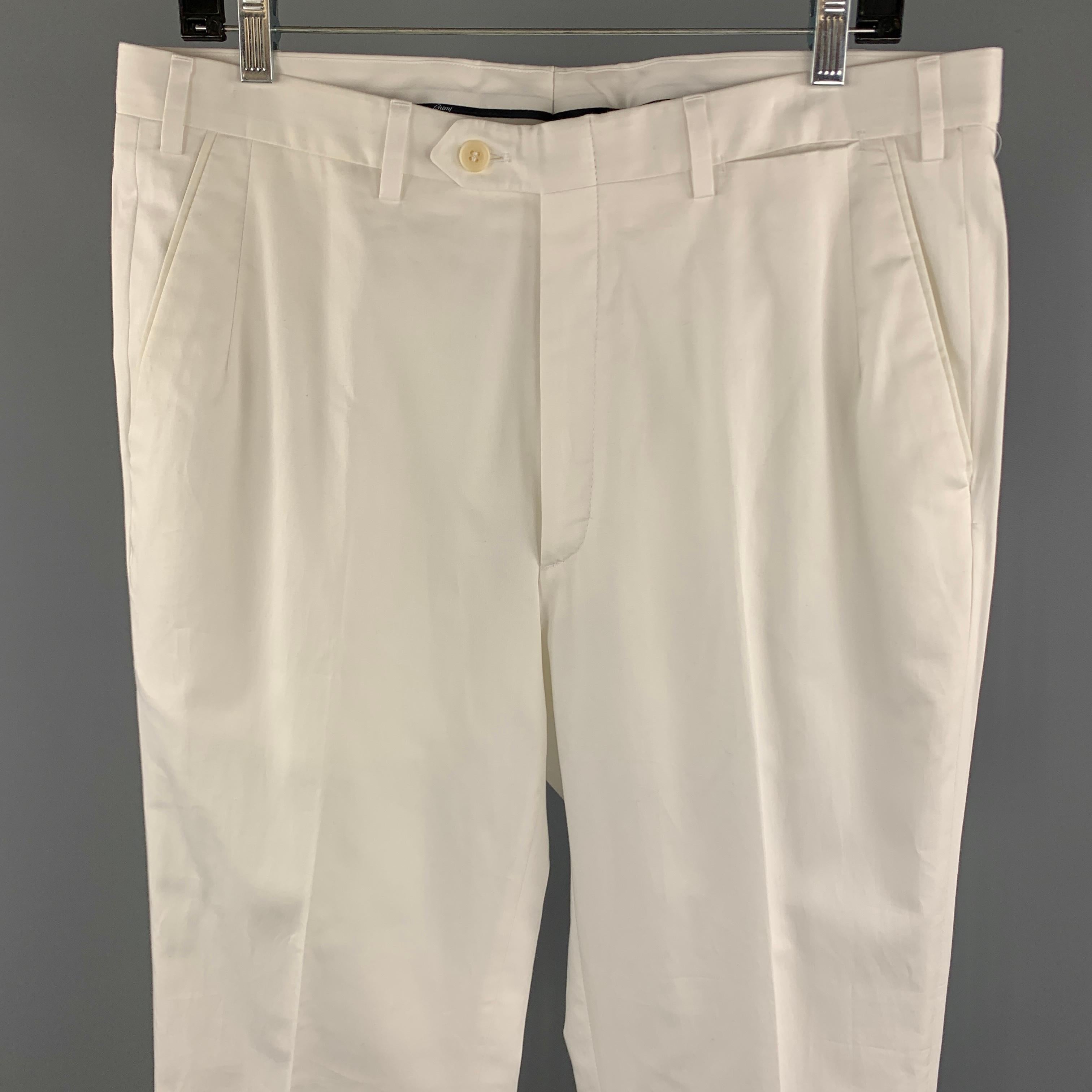BRIONI Dress Pants comes in a white cotton material, with a front tab, seam and zip pockets, cuffed, zip fly. Made in Italy. 

Excellent Pre-Owned Condition.
Marked: 34 R

Measurements:

Waist: 35 in. 
Rise: 12 in. 
Inseam: 31.5 in.