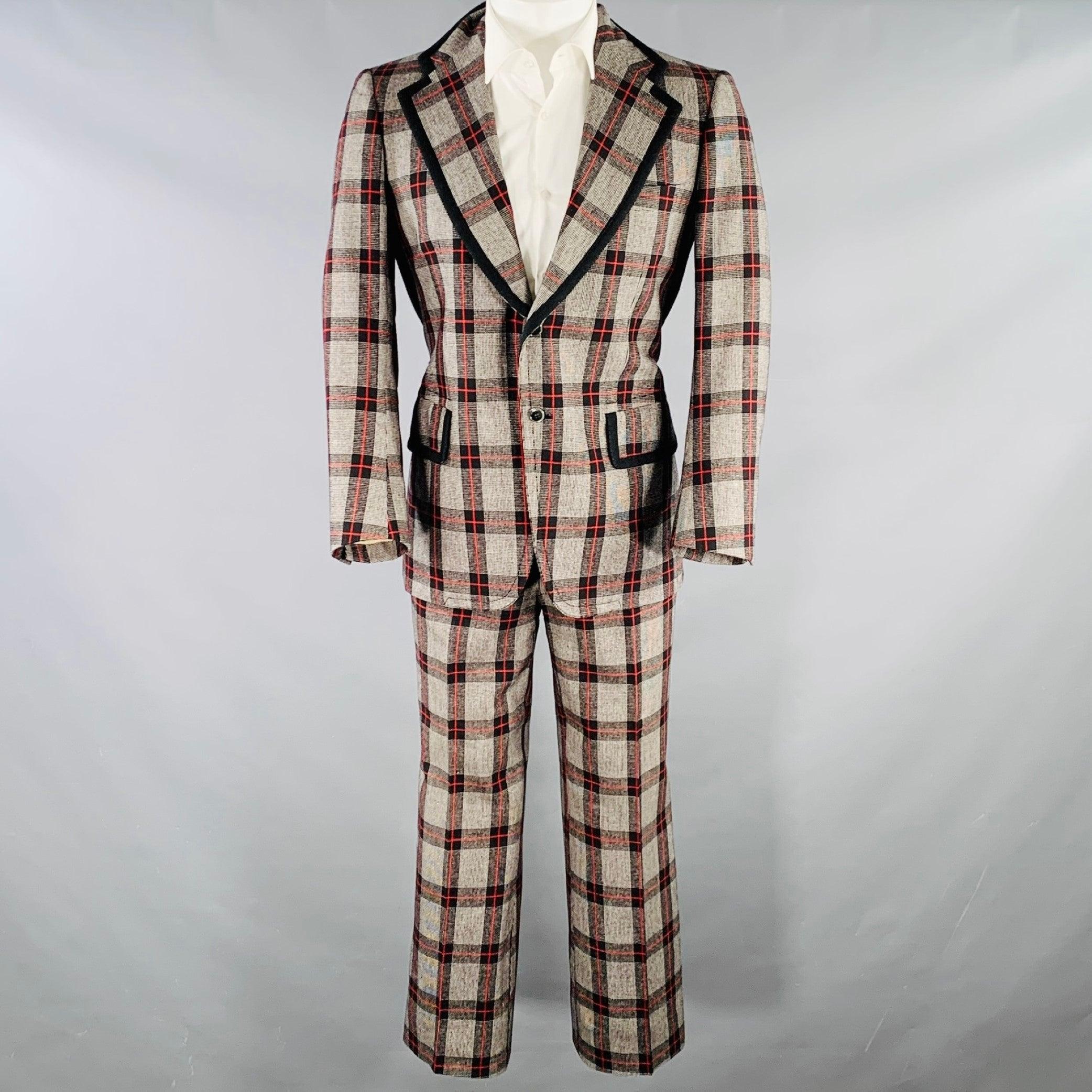 Vintage ROMAN STYLE by BRIONI suit
in a grey, black, and red plaid wool with a full liner and includes a single breasted, double button sport coat with a notch lapel and matching flat front trousers.
Made in Italy.Good Pre-Owned Condition. Minor