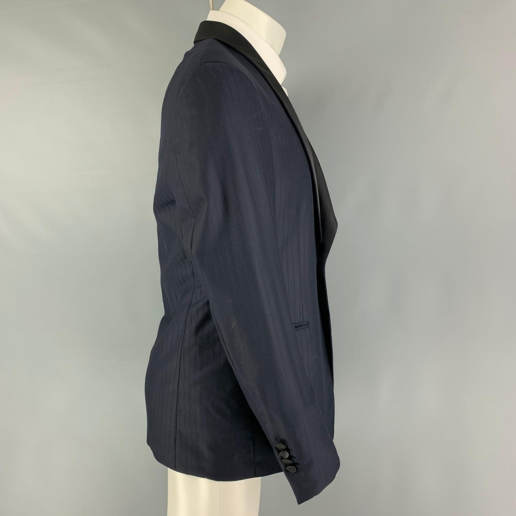 BRIONI
tuxedo sport coat comes in a navy stripe wool with a full liner featuring a shawl collar, slit pockets, and a single button closure.
Excellent
Pre-Owned Condition. 

Marked:   50 R  

Measurements: 
 
Shoulder: 17.5 inches Chest: 40 inches
