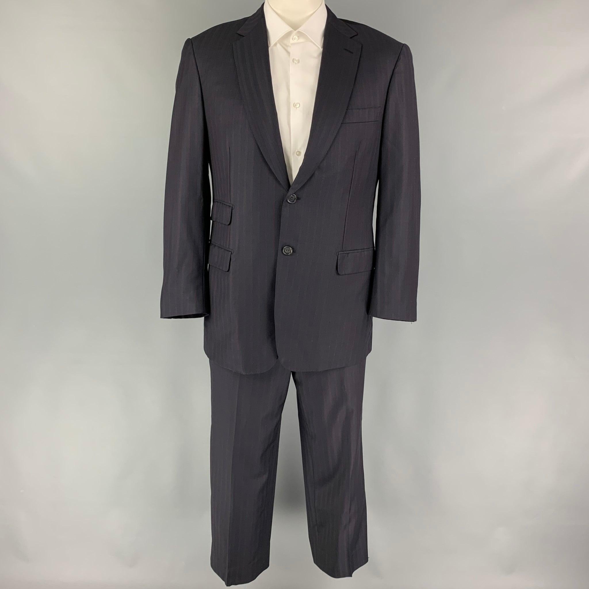 BRIONI
suit comes in a navy stripe wool with a full liner and includes a single breasted, double button sport coat with a notch lapel and matching flat front trousers. Made in Italy. Excellent Pre-Owned Condition. 

Marked:   42 R  

Measurements: 
