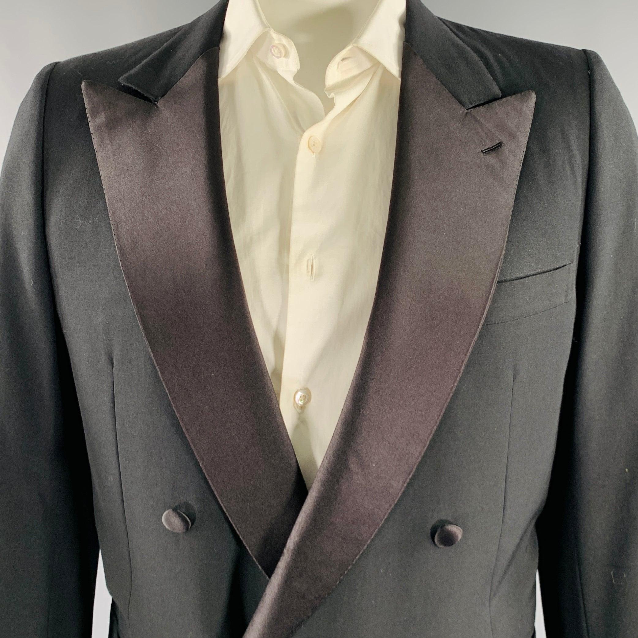 BRIONI tuxedo
in a black wool with a full liner and includes a double breasted, single button sport coat with a peak lapel and matching pleated trousers. Made in Italy.Very Good Pre-Owned Condition. Minor signs of wear. 

Marked:   46/56