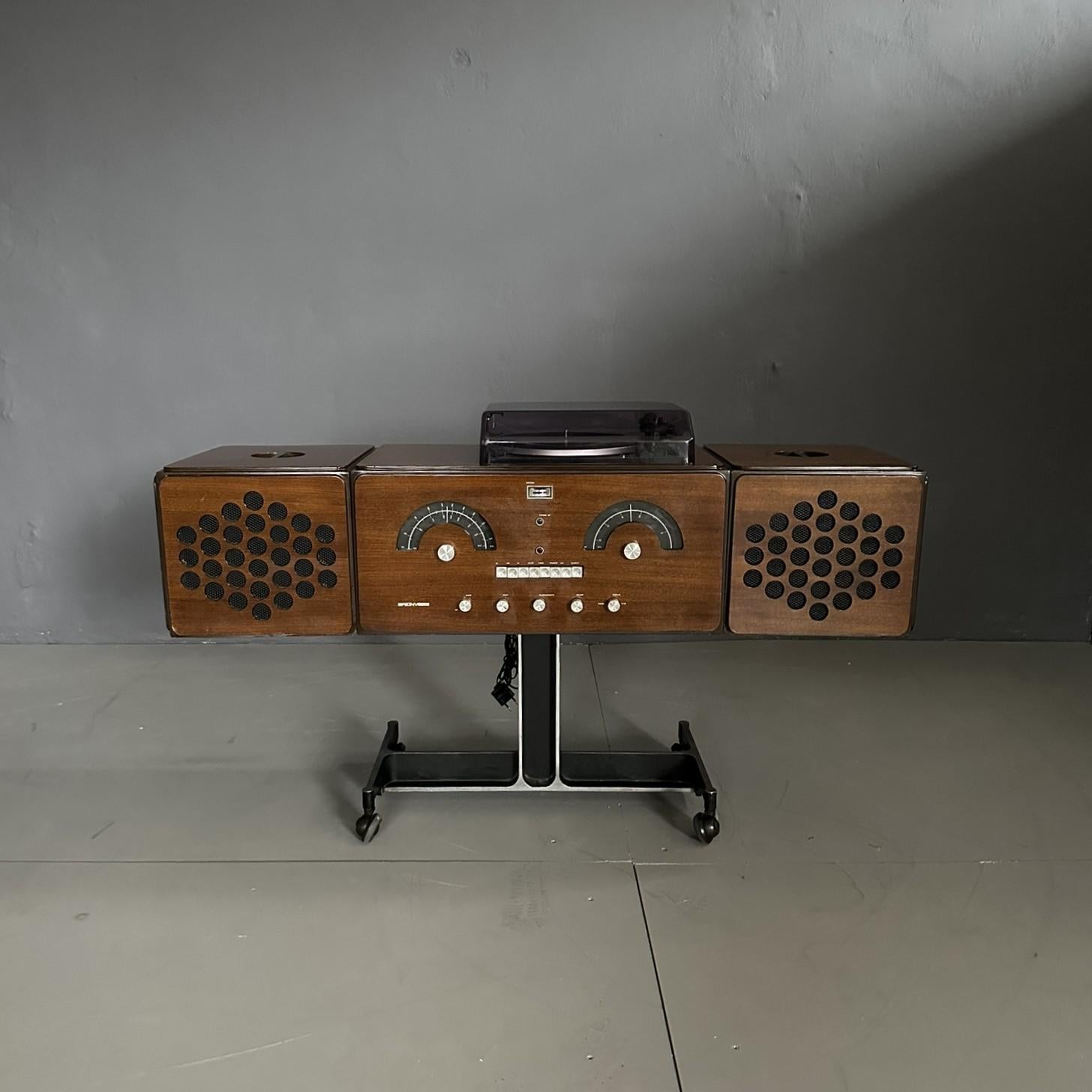 Brionvega RR126 radio phonograph in wood with teak finish, design by Achille and Pier Giacomo Castiglioni, produced and commissioned by Brionvega Milano, 1964.

Made of wood with metal base on wheels; which allow the object to be easily moved to any