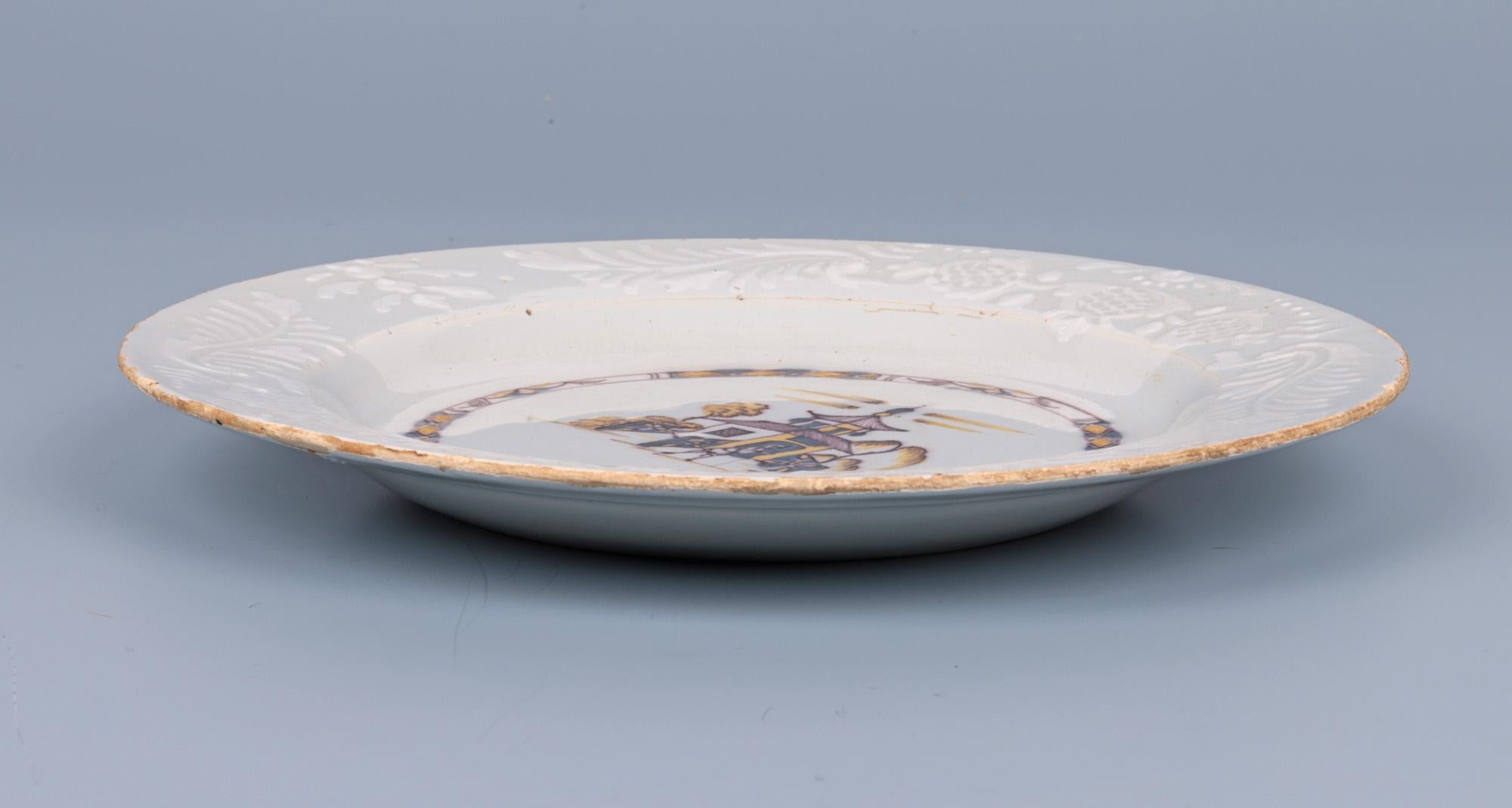 Très belle assiette ancienne anglaise de Bristol Delft peinte à la main d'une scène chinoise et datant du milieu du XVIIIe siècle. L'assiette en poterie repose sur un étroit bord de pied non émaillé et est de forme ronde avec un bord plat surélevé.