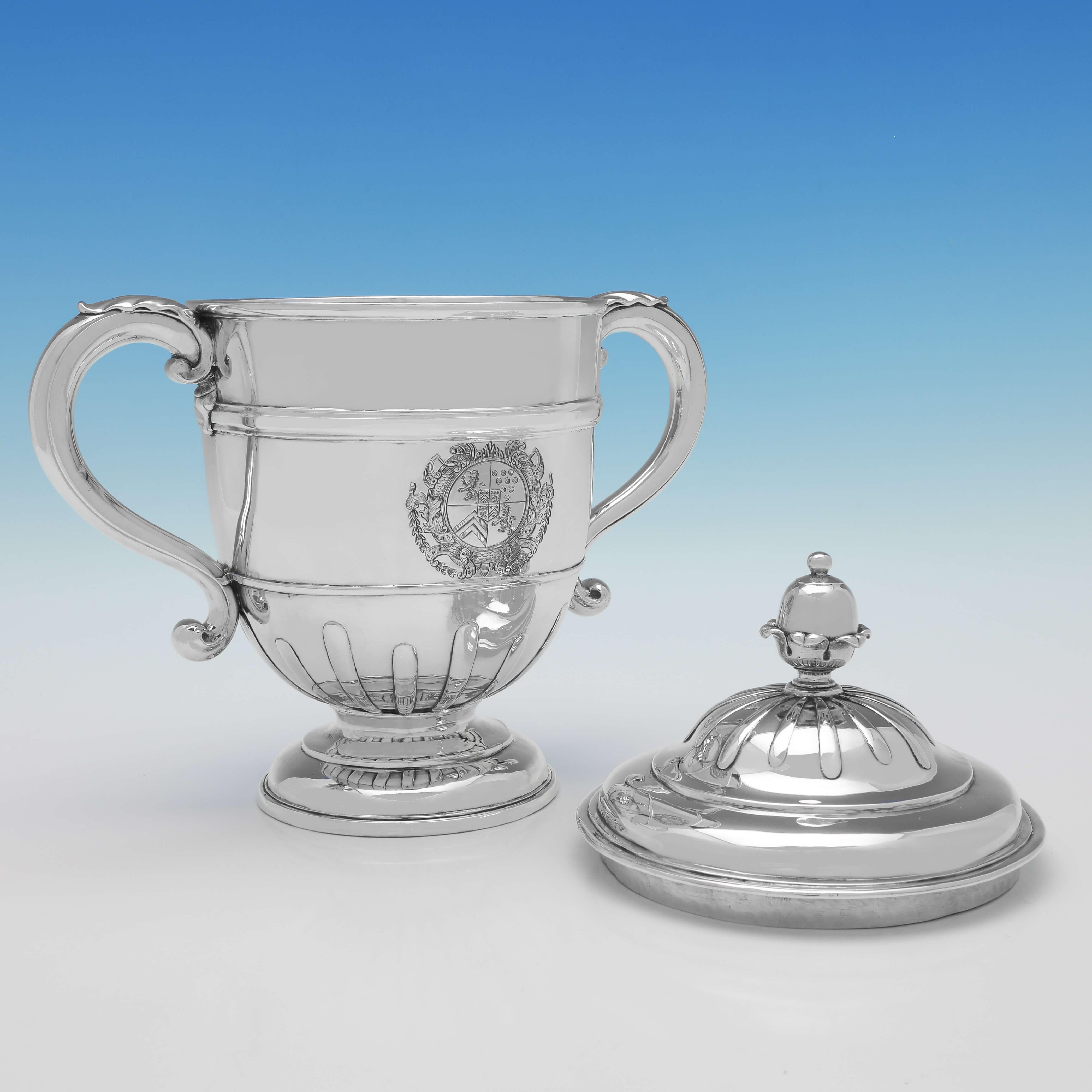 Hallmarked in London in 1716 by Lewis Mettayer, this striking, George I, Antique Britannia Standard Silver Cup & Cover, features strap work to the body and lid, acanthus detailed handles and an engraved armorial to one side. The lid of the cup is