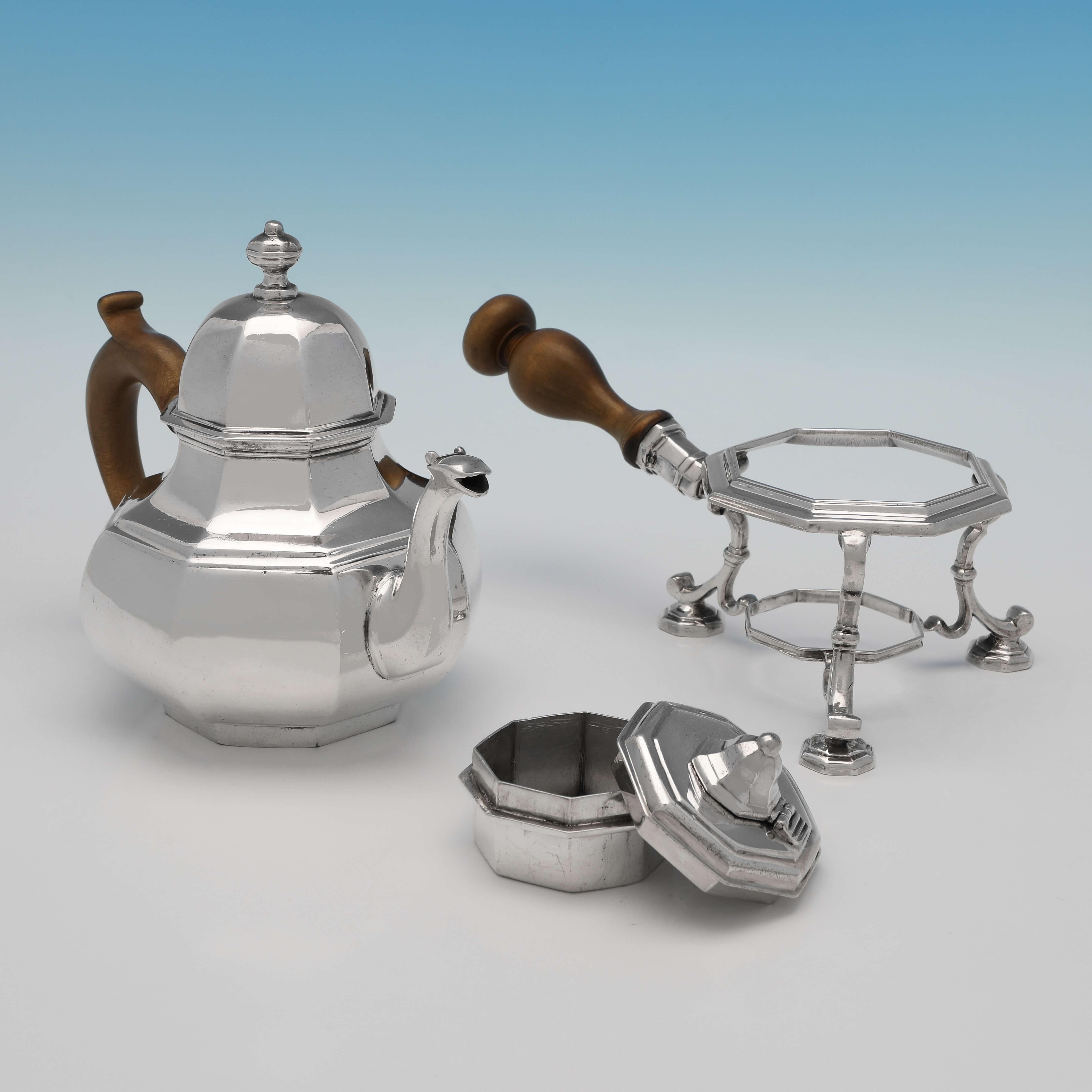 Hallmarked in London in 1712 by William Penstone III, this very handsome and incredibly rare, Queen Anne, antique Britannia standard silver teapot on warming stand, is of pear shaped octagonal form, plain in style and with wooden handles to both the