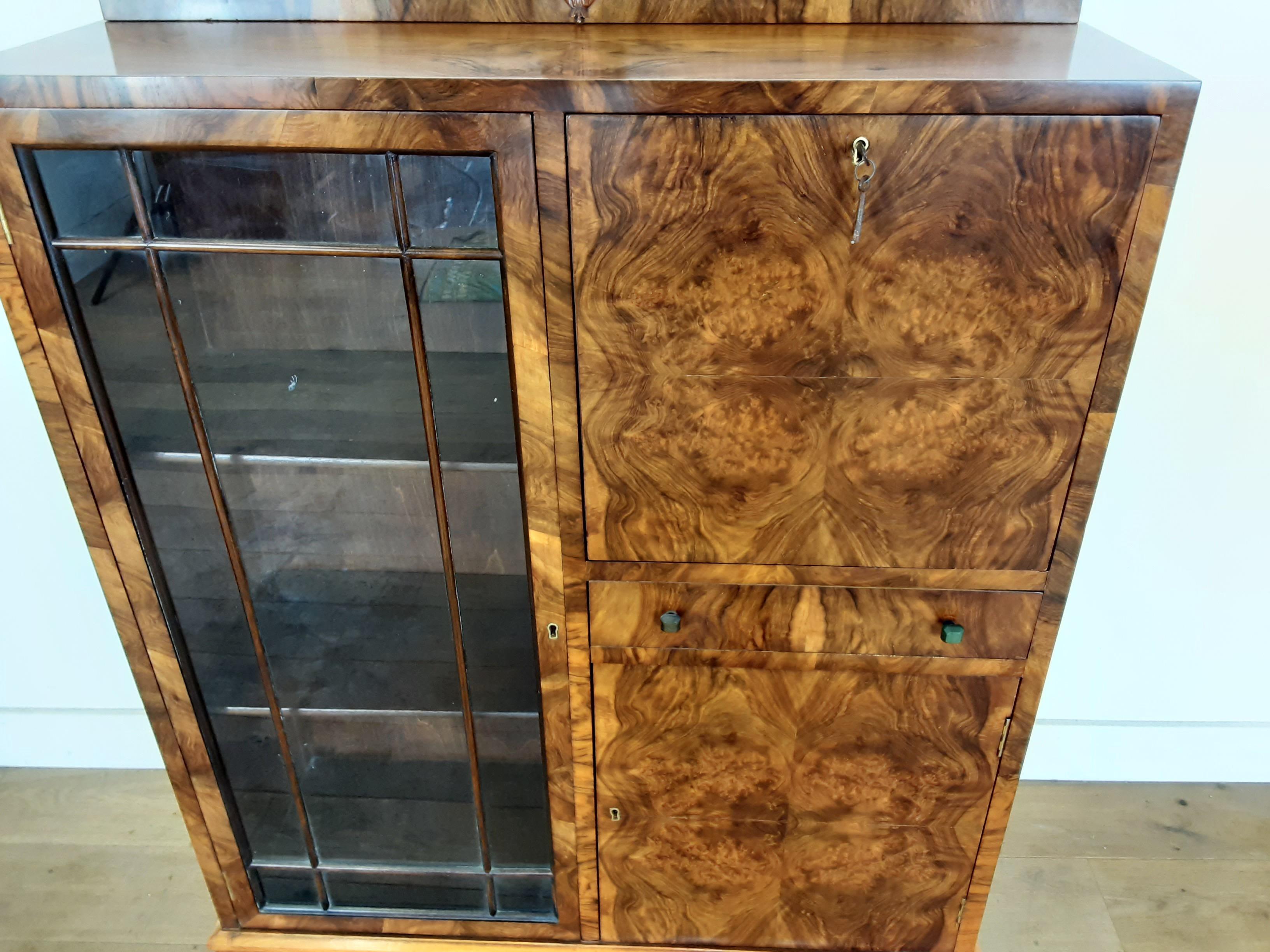 Art Deco bureau
Art Deco display bookcase,
A walnut Art Deco cabinet incorporation a bureau and bookcase display cabinet .
The right side has a fold down writing shelf the compartment fitted with pigeon holes, over a single drawer and
