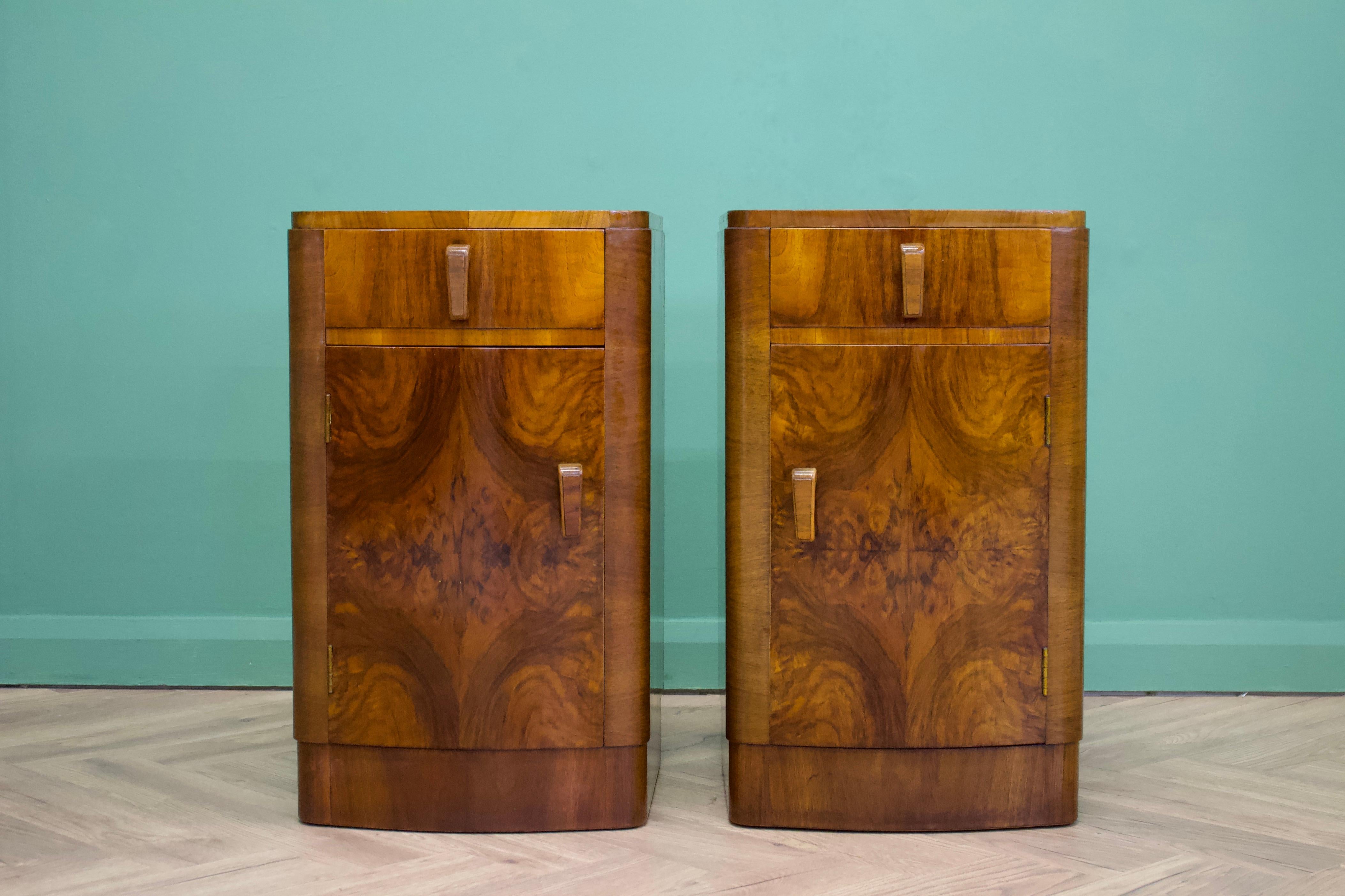 - Art Deco bow fronted pair of bedside tables
- Manufactured in the UK.
- Made from solid oak and burr walnut veneers.
- Featuring a drawer and cupboard with a shelf to each