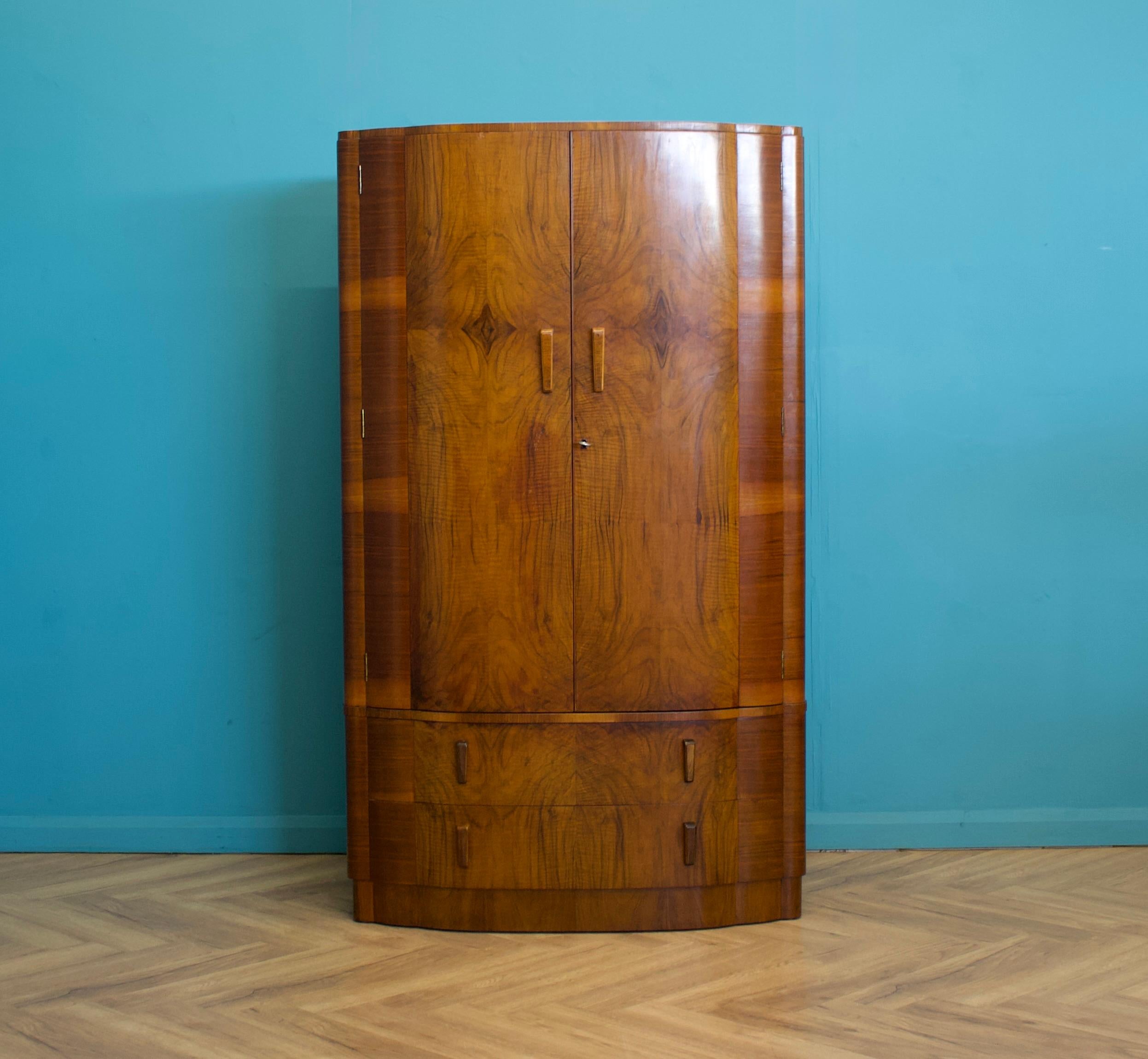 An Art Deco walnut wardrobe  - circa 1930's -
With an oak lined interior, fitted out with a wooden clothes rail, shelves and drawers


Featuring decorative wooden handles
The wardrobe does separate into two ( a drawer base and top )


The matching