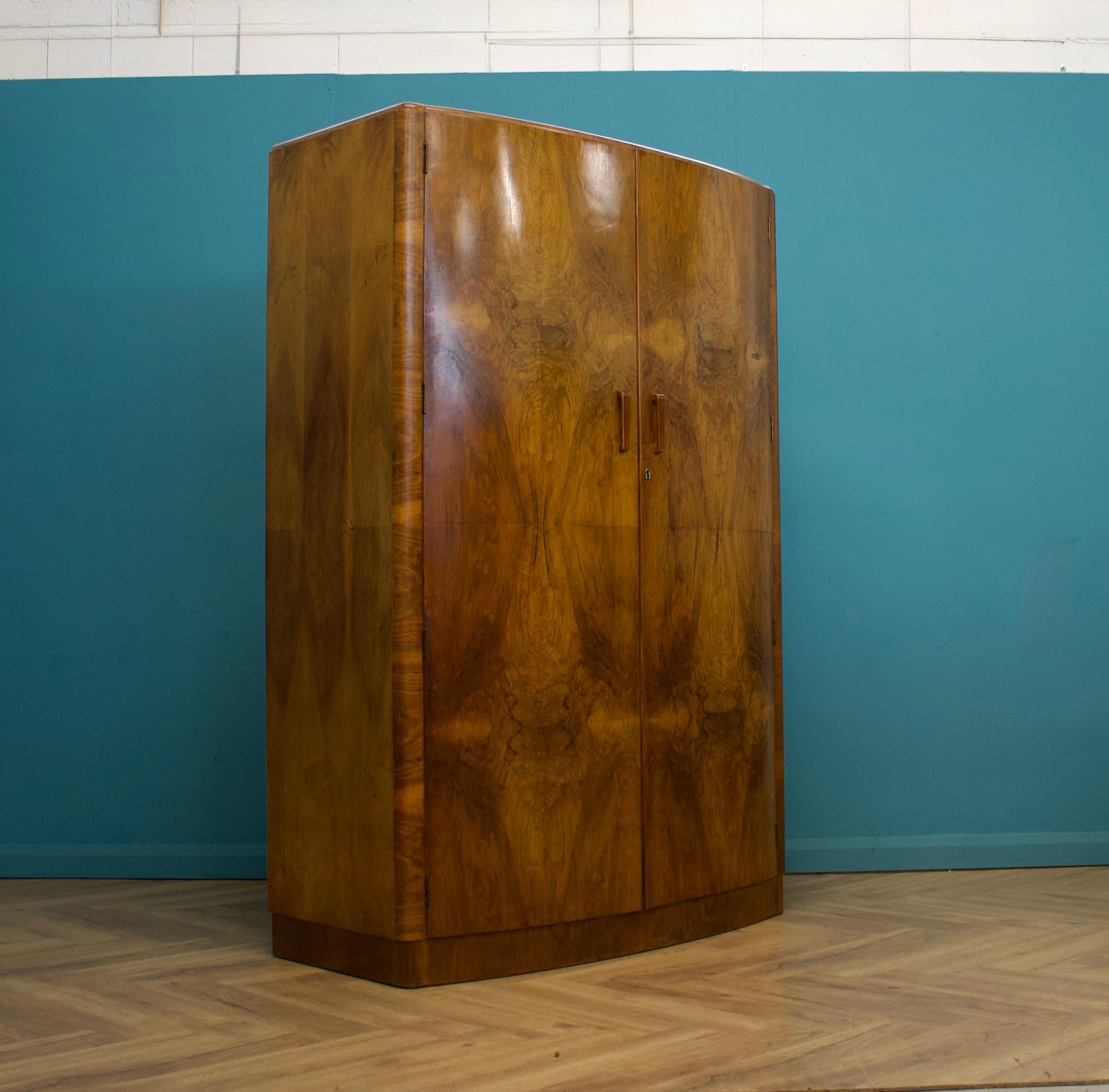 Armoire Art Déco en noyer  - circa 1930's - 
Intérieur doublé en chêne, équipé de deux tringles à linge en bois et d'une étagère. 
 
Poignées décoratives en bois
L'armoire se sépare en deux parties 
