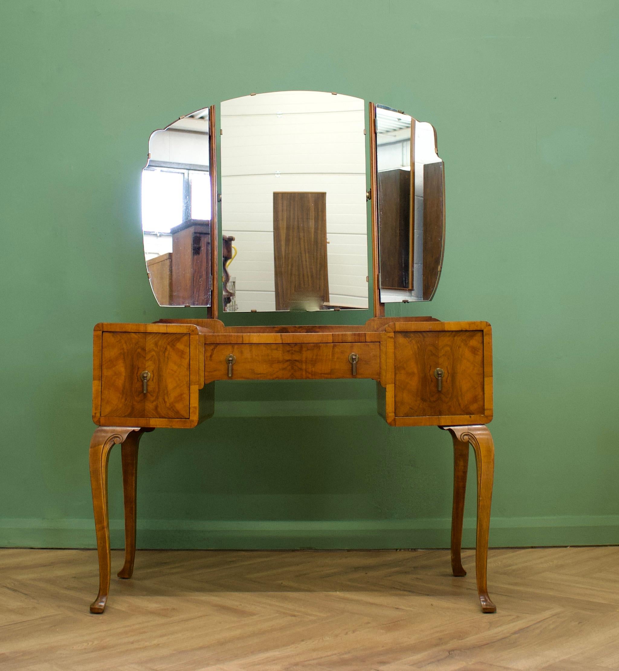 1930's Walnut Dressing Table

An impressive quality 1930s Deco dressing table
Very similar in style and quality to Waring and Gillow

Featuring three drawers and a triptych mirror

Height to top of the mirror is 149cm.