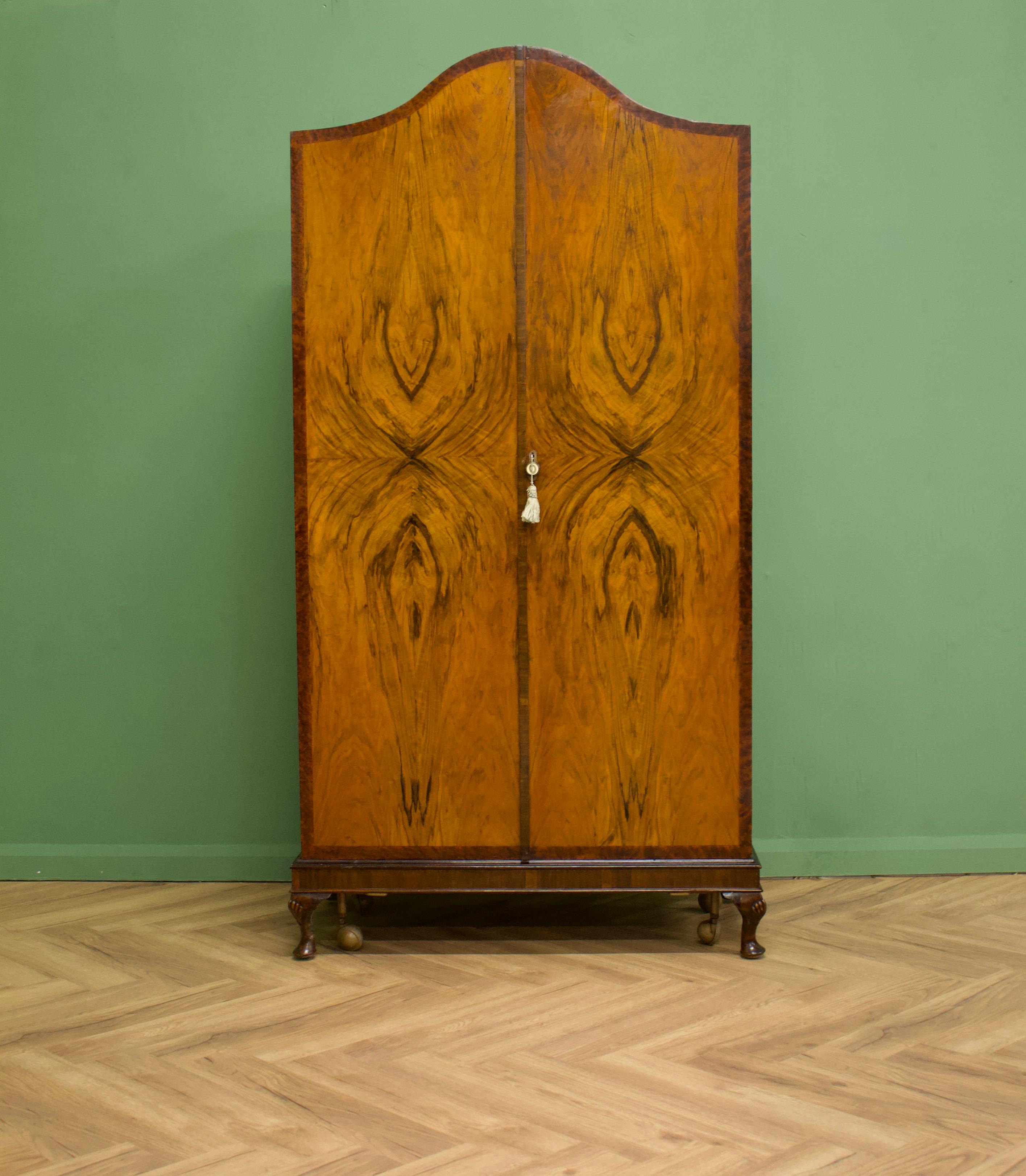 - Art Deco wardrobe
- Manufactured in the UK - in the style of Waring and Gillow
- Made from solid wood and burr walnut veneers
- The wardrobe sits on castors which are removable
- Featuring internal full length mirror, a pull out hanging rail,