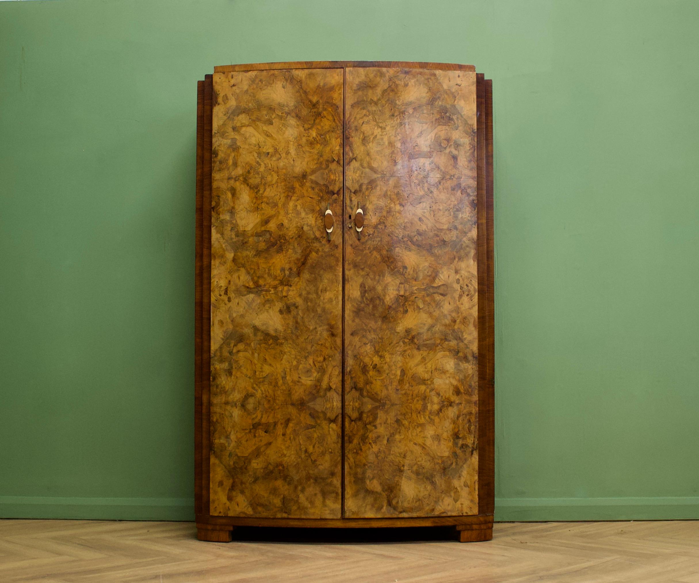 An Art Deco walnut wardrobe
Complete with unique metal, bakelite and walnut handles  - circa 1930's
Fitted out with two clothes rails and a shelf