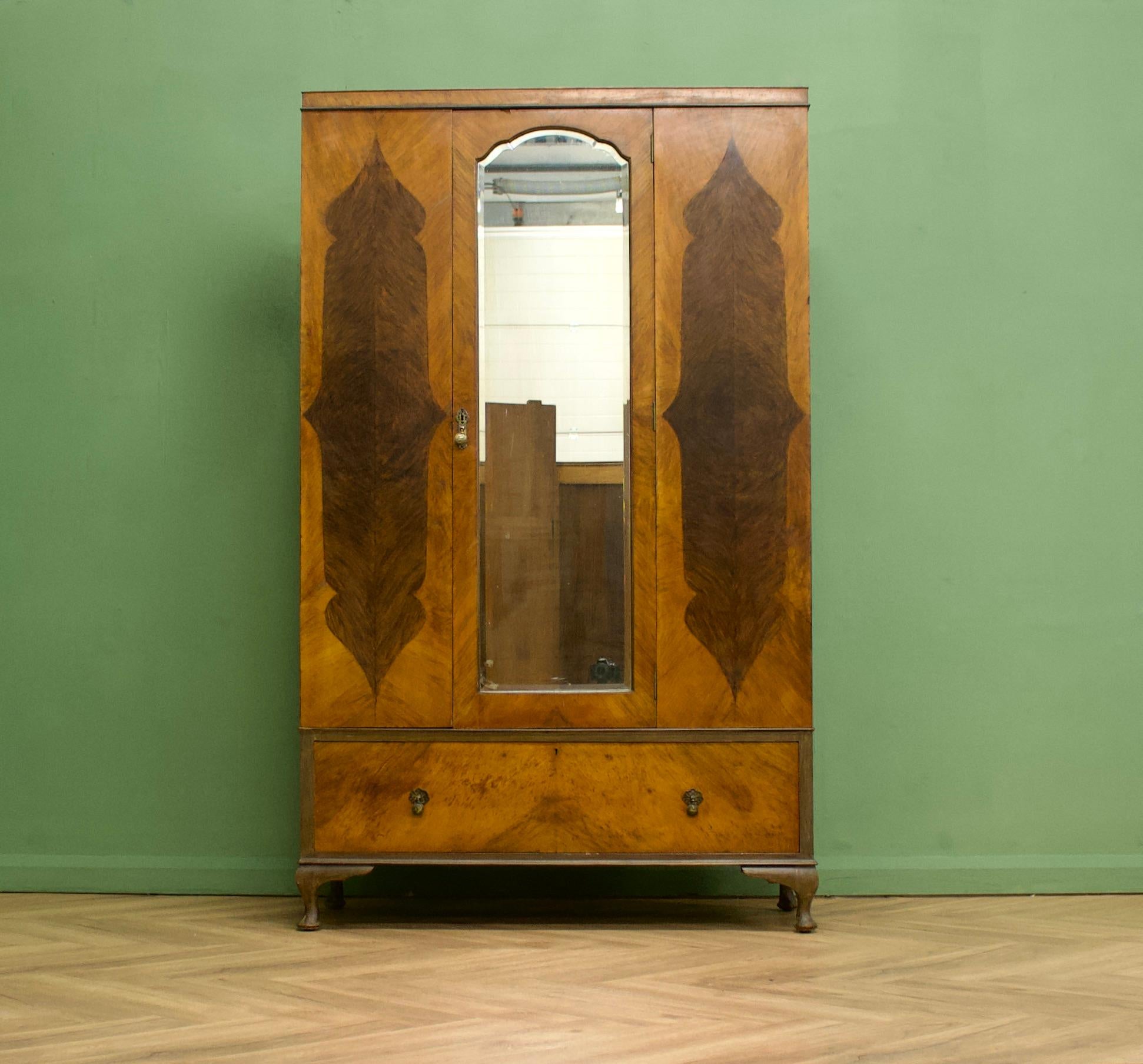 Ein Art-Deco-Schrank aus Nussbaumholz von der Qualitätsmöbelmanufaktur Jas Shoolbred - circa 1920er Jahre
Ausgestattet mit einer Kleiderstange und Kleiderhaken
In der unteren Schublade gibt es weiteren Stauraum