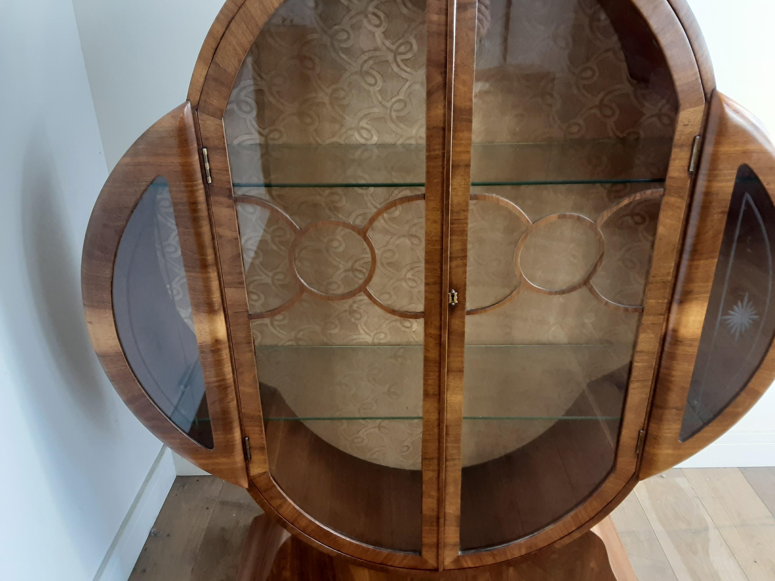 British Art Deco walnut display cabinet.
Stunning and rare cloud shape display cabinet in a nice figured walnut with a circular fretwork design to the glass panel doors.
British, circa 1930.
Measures: 139 cm H, 120 cm W, 32 cm D.