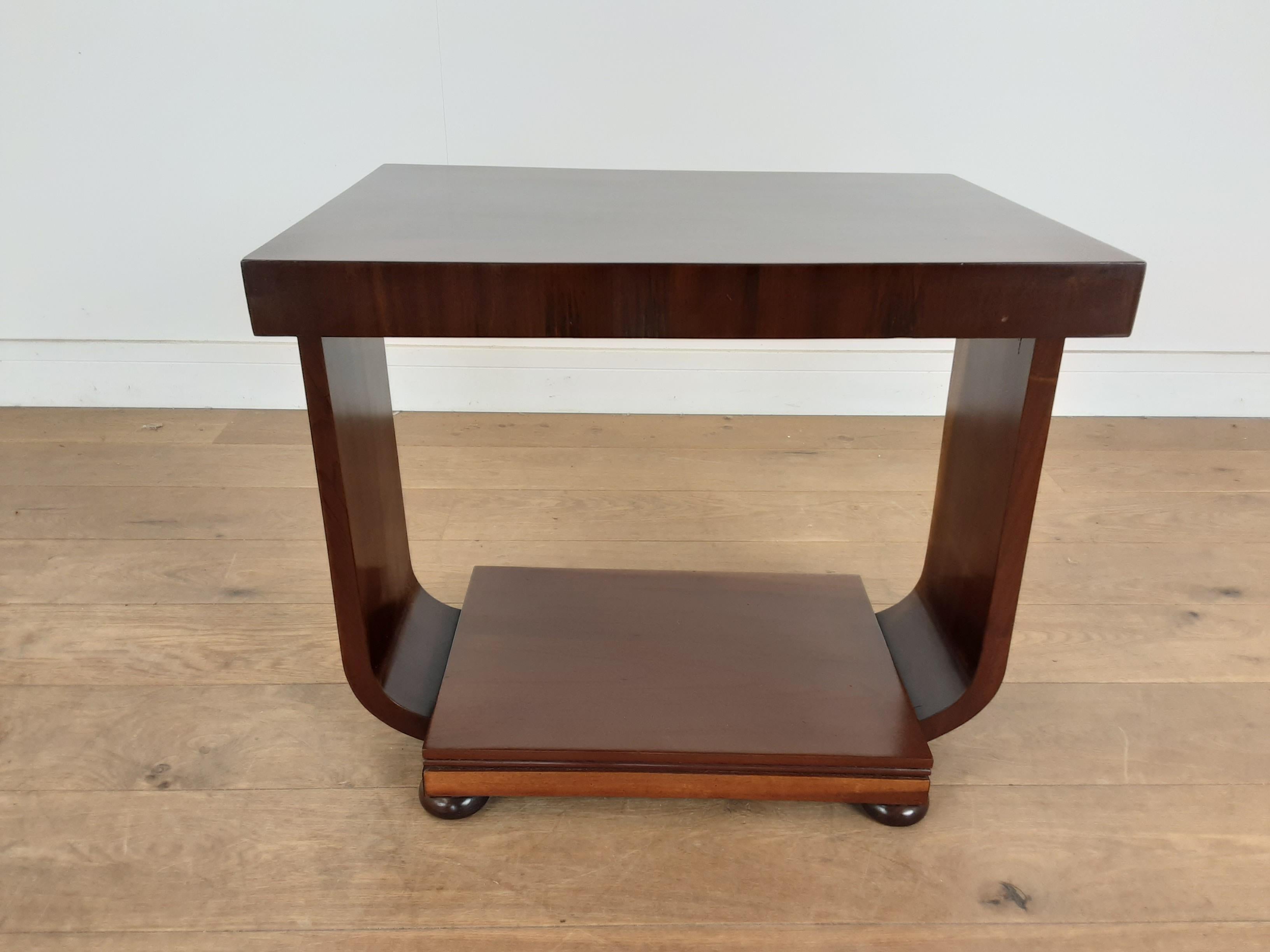 Art Deco table
Art Deco two-tier table with rectangle top in burr walnut with a walnut boarder, the straight flat sides with curved lower section which meets the base plinth, raised on bun feet.
British, circa 1930.
Measures: 53 cm H, 62 cm W, 45