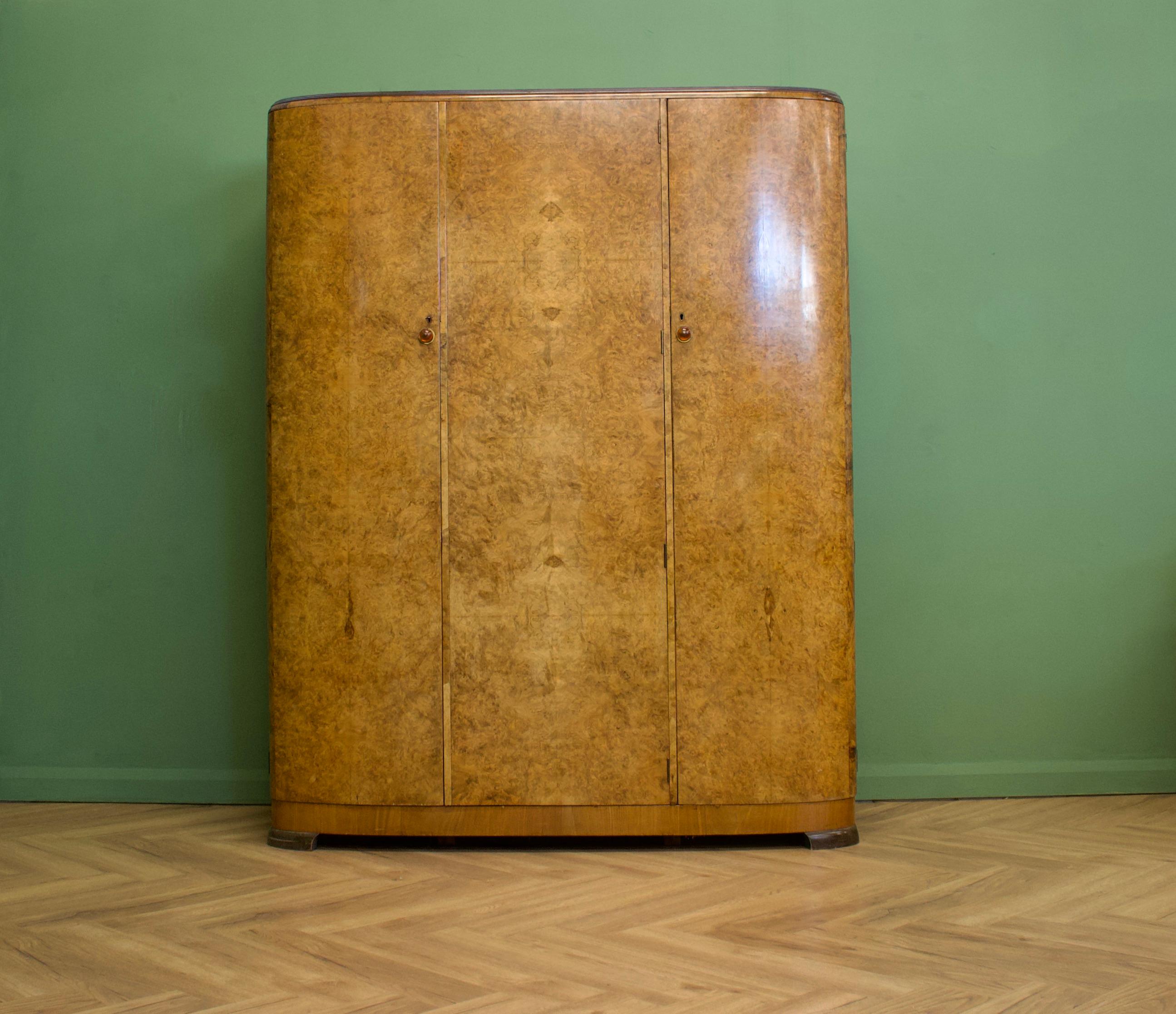 An impressive quality 1930s Deco burr walnut triple door wardrobe
Fitted out beautifully - to one side is a rail and shelf, to the other shelves and compartments and a mirror to the door
The handles are amber coloured bakelite