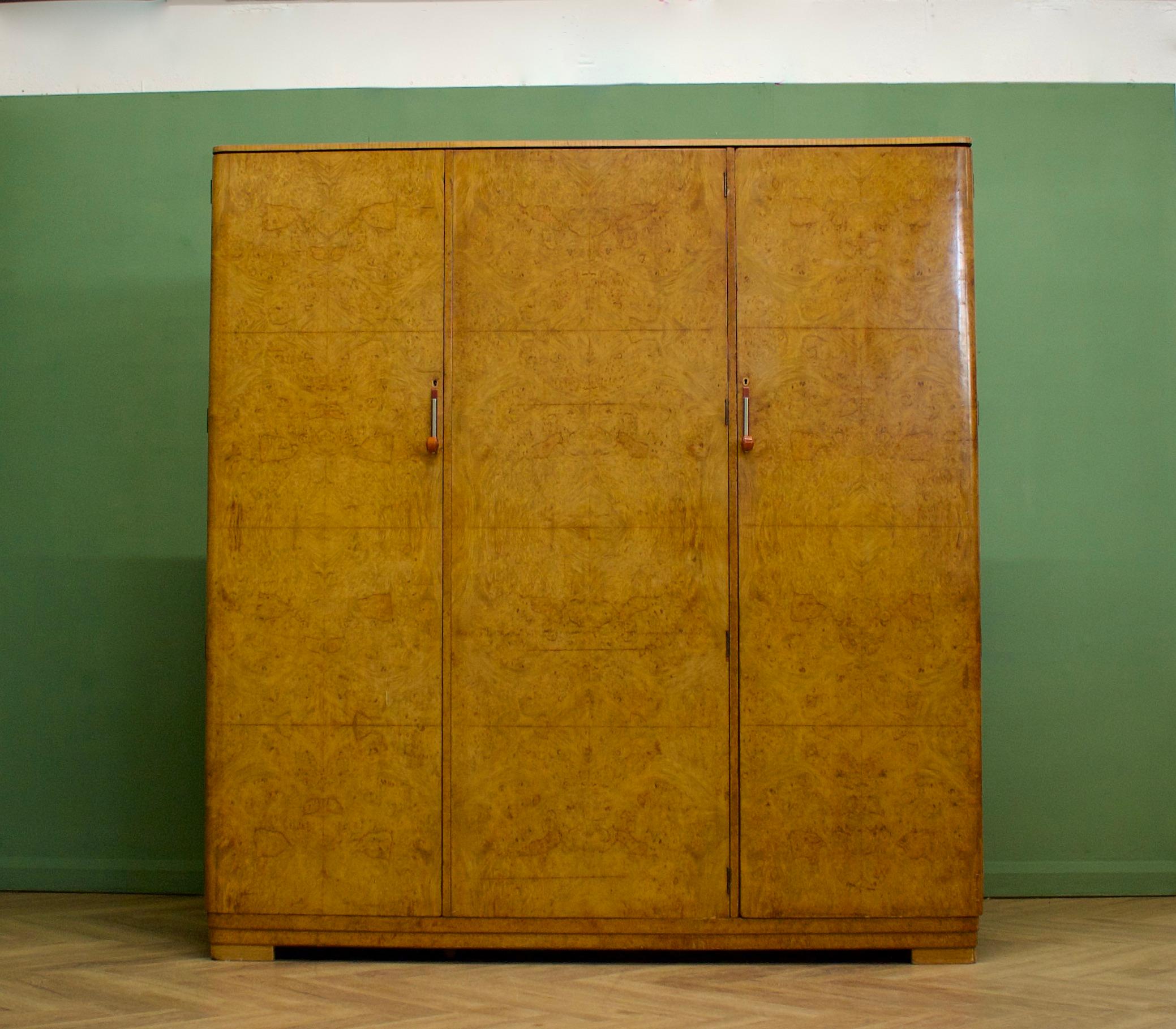 Hochwertiger Art-Déco-Schrank aus Nussbaumholz von Maple and Co, ca. 1930er Jahre
Komplett mit einzigartigen Metall- und Bakelitgriffen
Wunderschön ausgestattet mit einer Kleiderstange an einer Seite  und ein Regal und Schubladen zum anderen