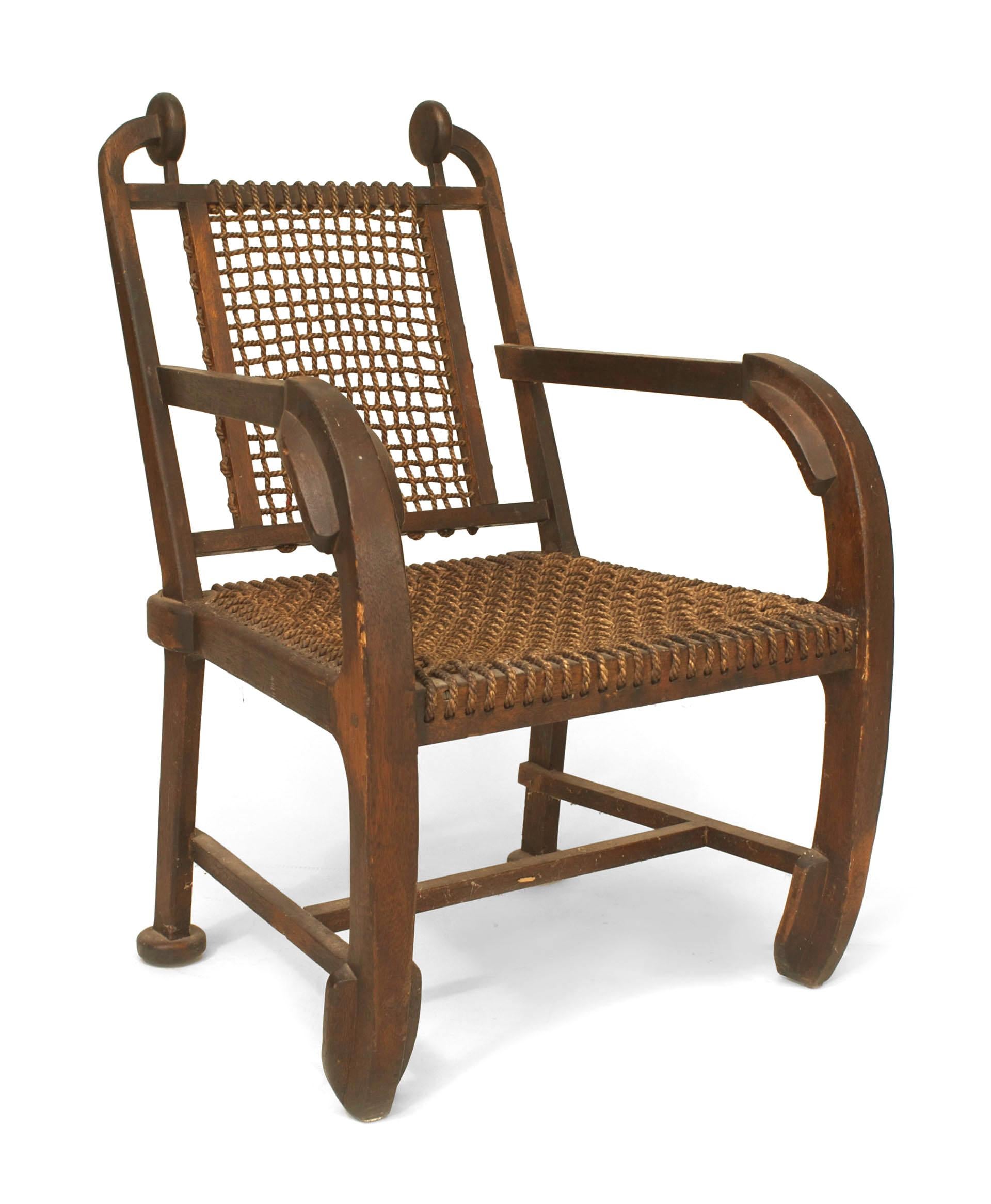 English (possibly Scottish) Arts & Crafts rustic design dark stained oak arm chair with nautical paddle form arms and legs with a woven rope seat and back.
