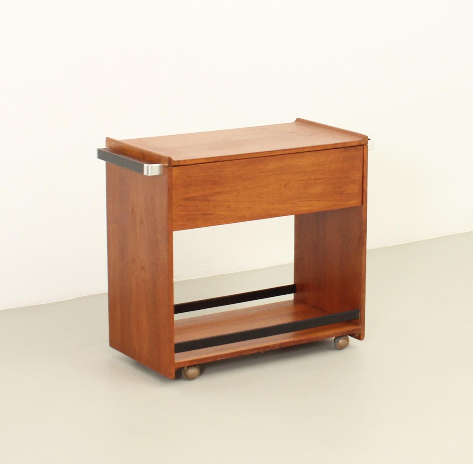 Bar cart in teak wood produced by British company Eedee, 1960's. Teak wood and polished and lacquered aluminum. Two trays and a storage space. 