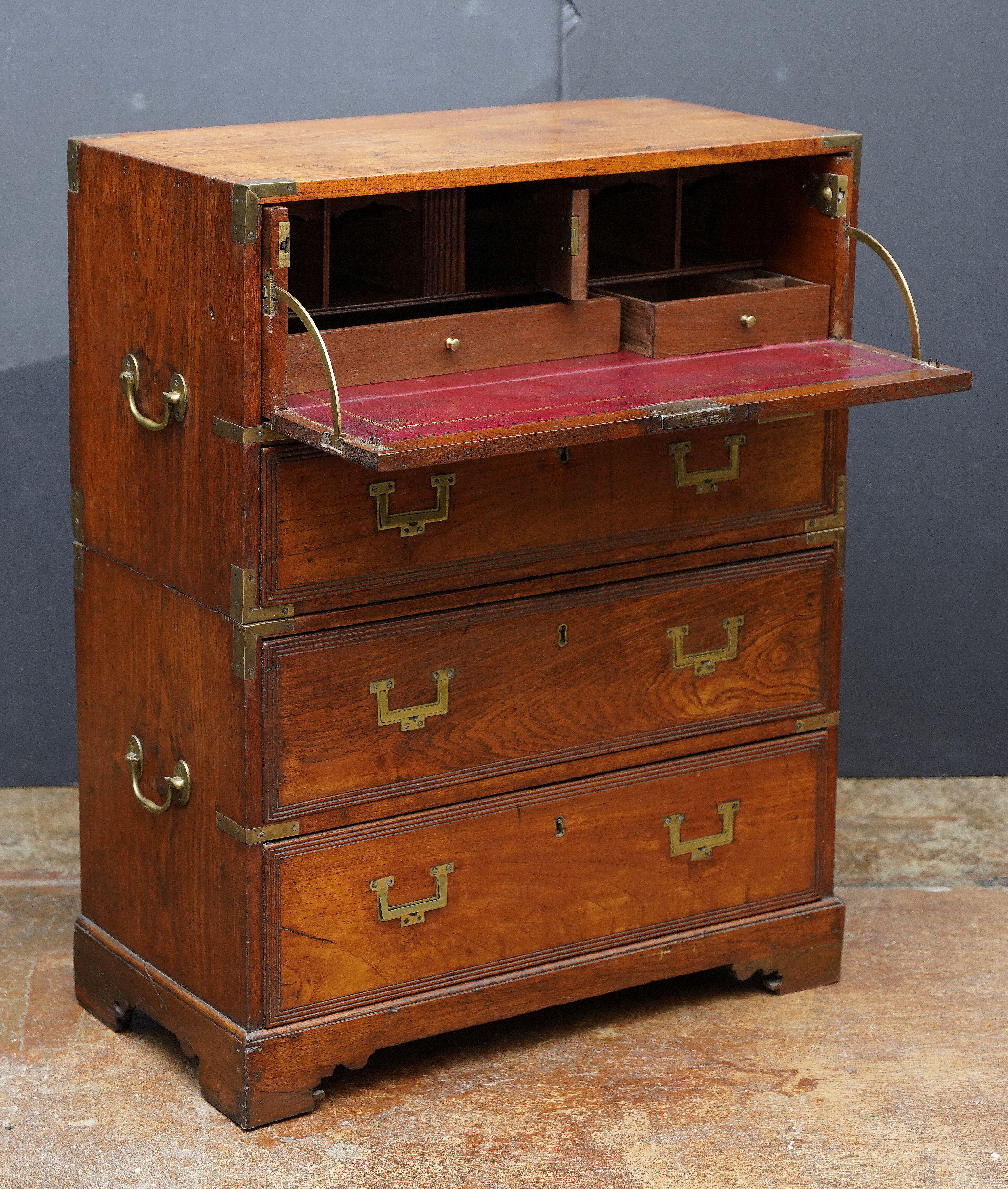 A fine British military officer’s Campaign secretary or secretaire from the early 19th century Georgian Era, of a desirably rare and diminutive scale, fashioned as a chest of drawers.

Featuring a patinated wood exterior, showing four long drawers.