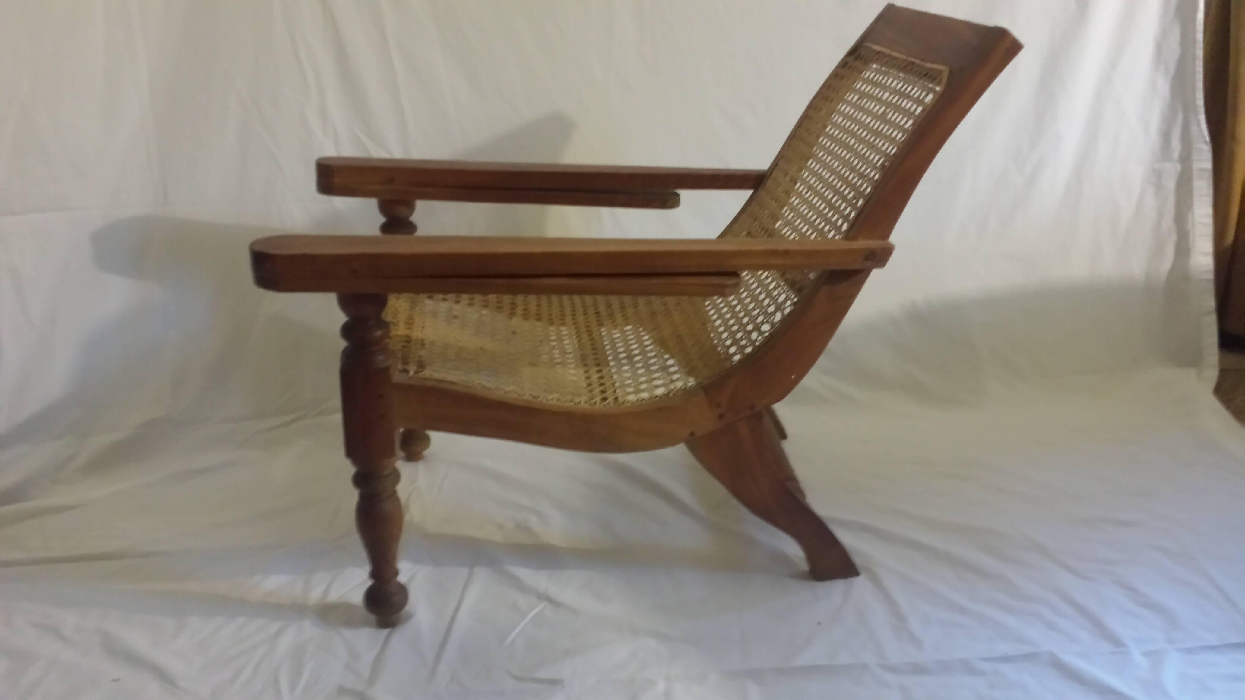 A rare British Colonial, Ceylonese, child's plantation or planters chair in solid satinwood, handmade pegged construction, hand canning and footrest extensions (40 inches when extended).