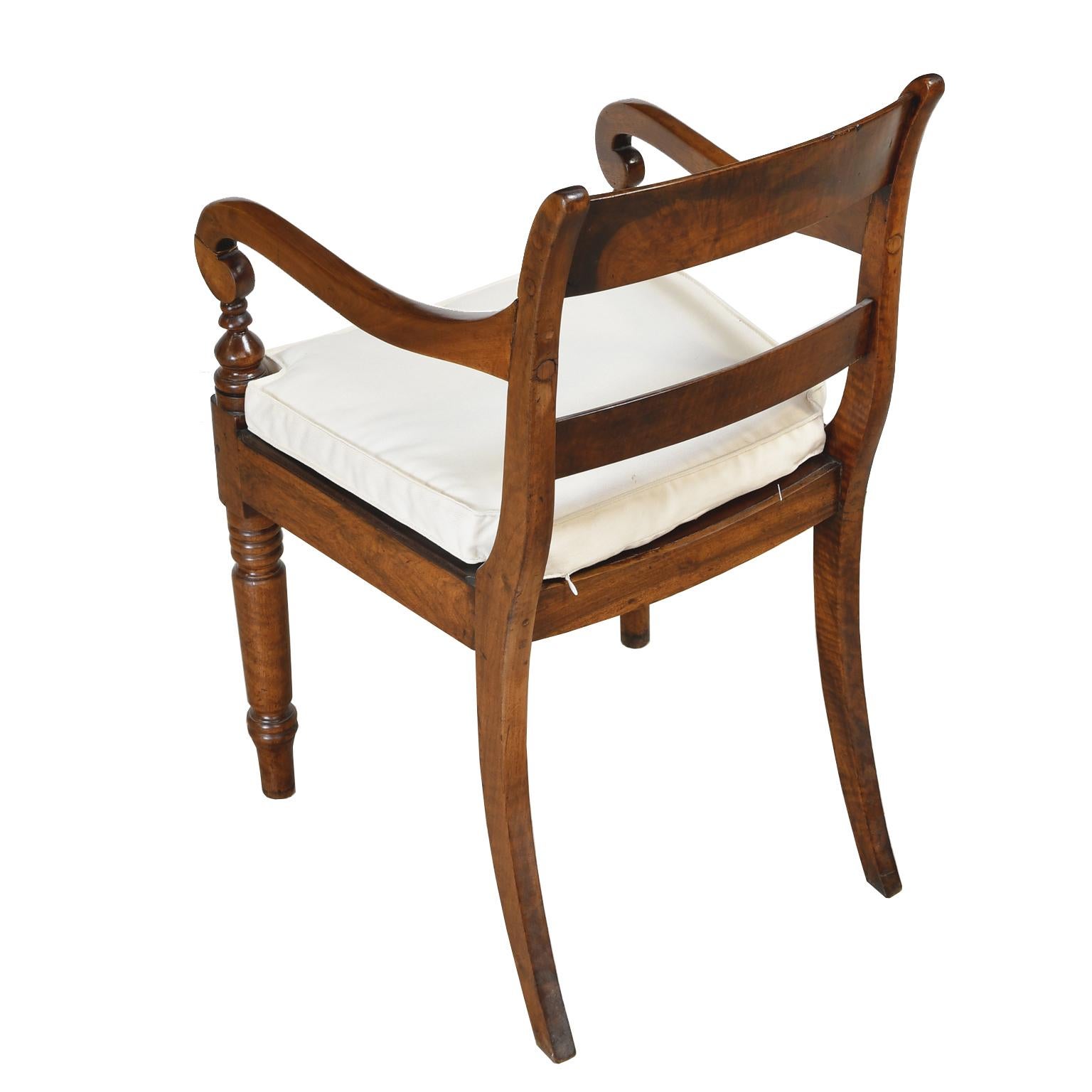 A handsome William IV desk chair in walnut with slat-back, scoop seat, scroll arms and turned legs. British Colonial, circa 1830.

Measurements: 20 1/2