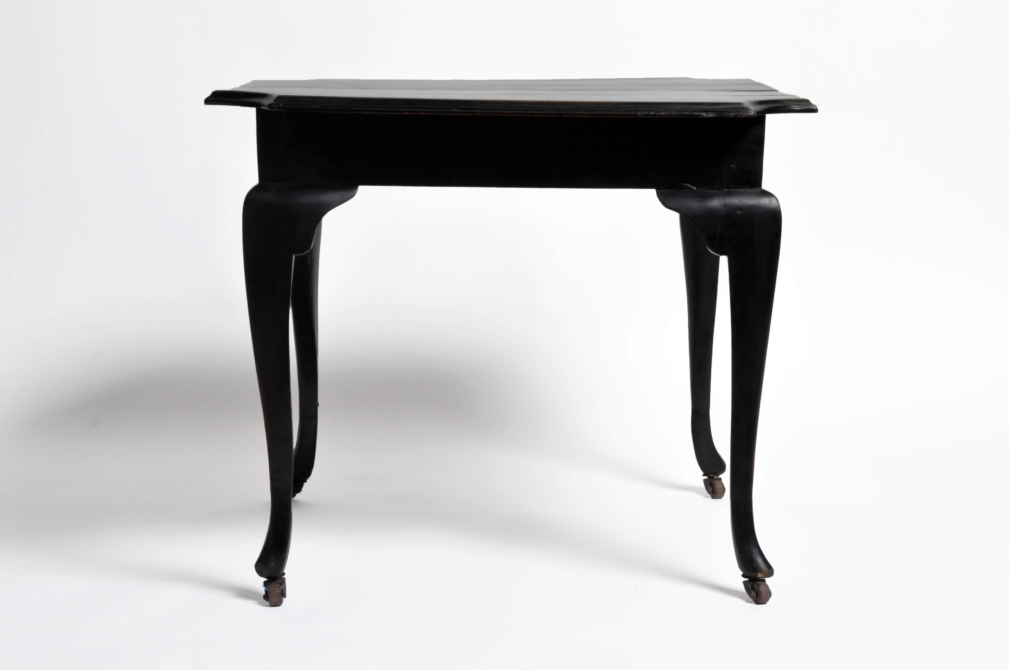 This British Colonial Art Deco tea table is from Yangon and was made from teak wood, circa 1940. It features a new black lacquer finish and casters on all four legs.