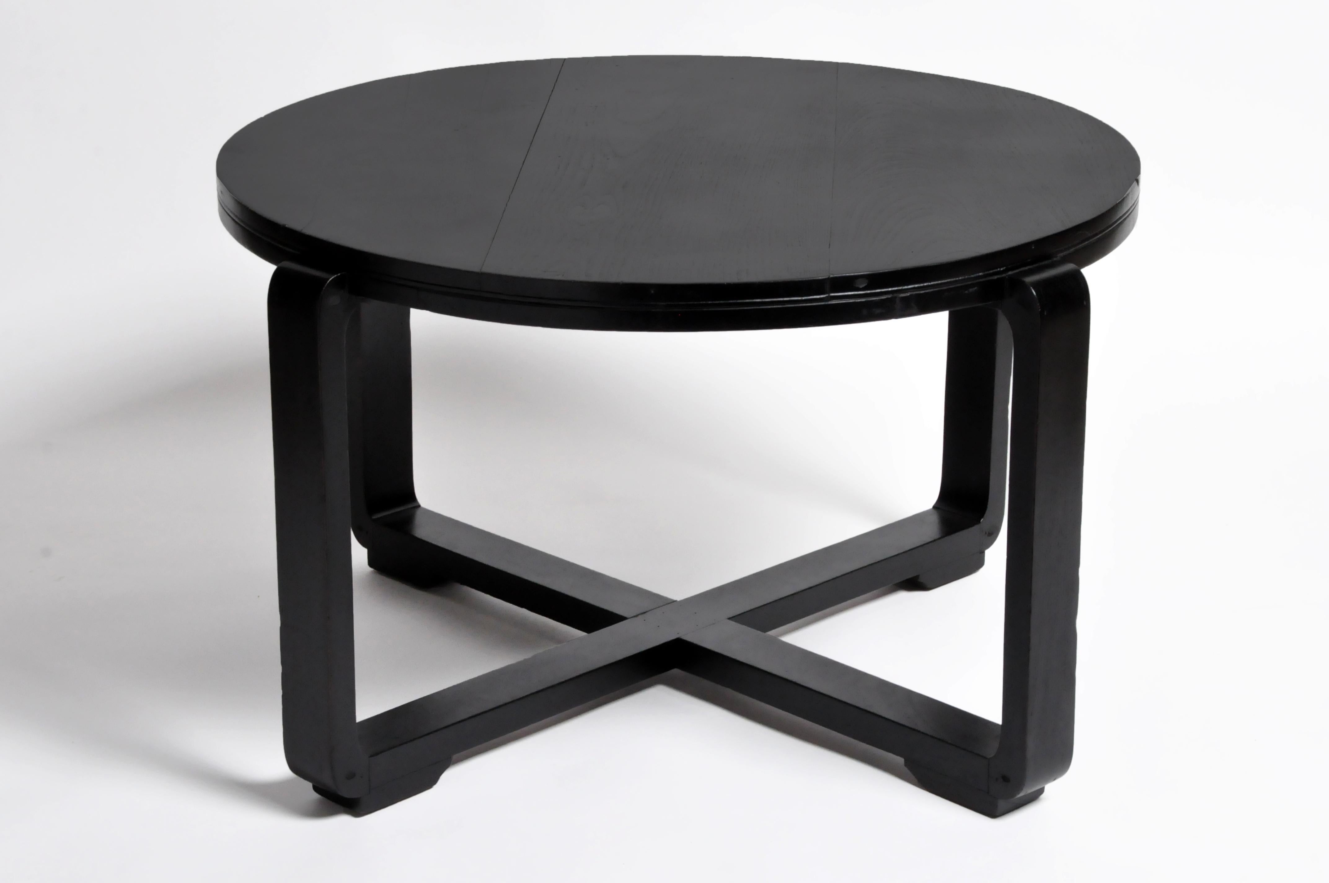 This British Colonial Art Deco round tea table is from Yangon and was made from teak wood, circa 1940. It features a new black lacquer finish with intersecting legs forming an 