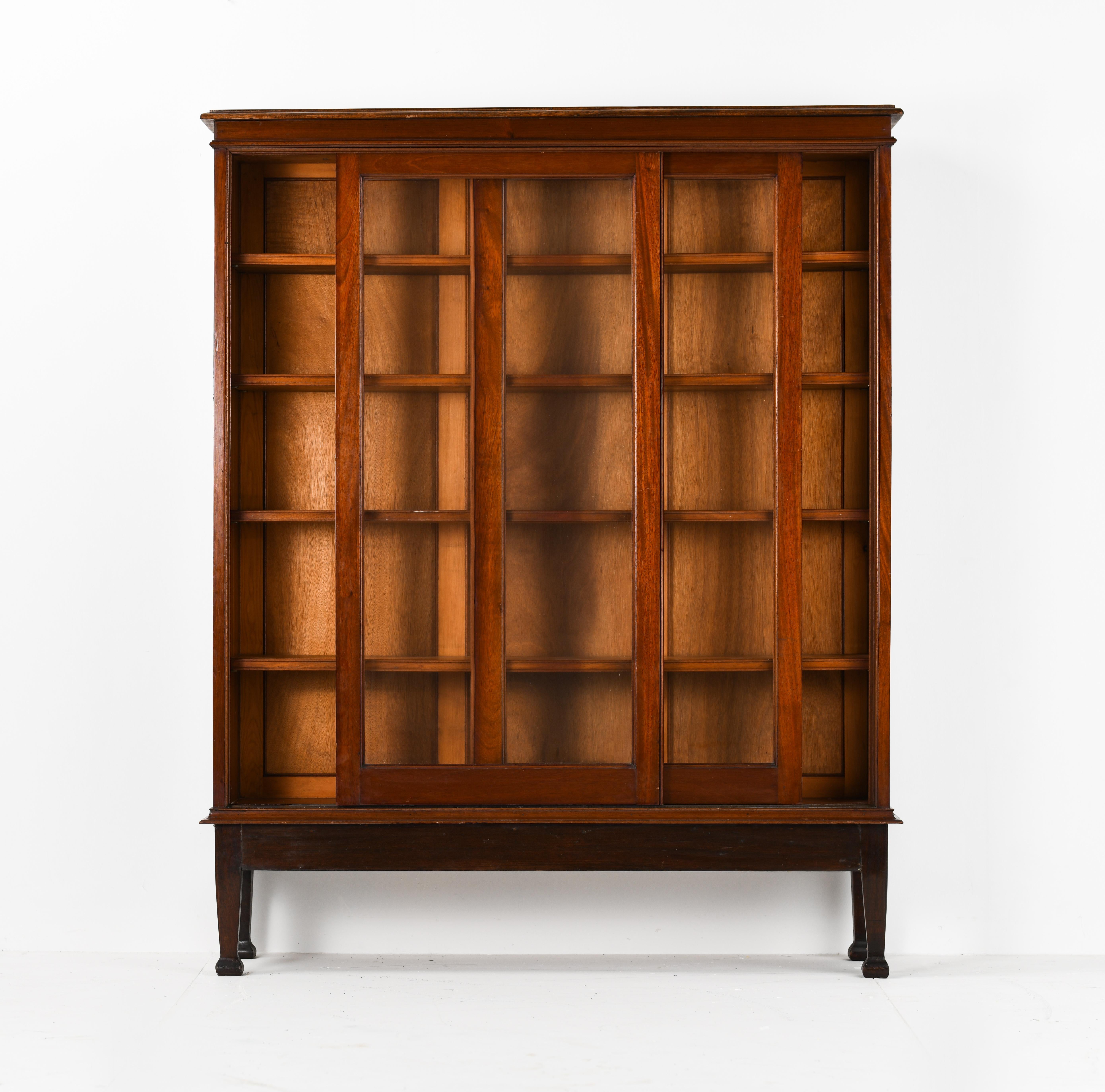 This handsome British Colonial bookcase with very good proportions it’s made from Burmese teak and dates, circa 1950s. This bookcase features a set of sliding glass panel doors teak framed that open to compartments lined with 4 shelves and original