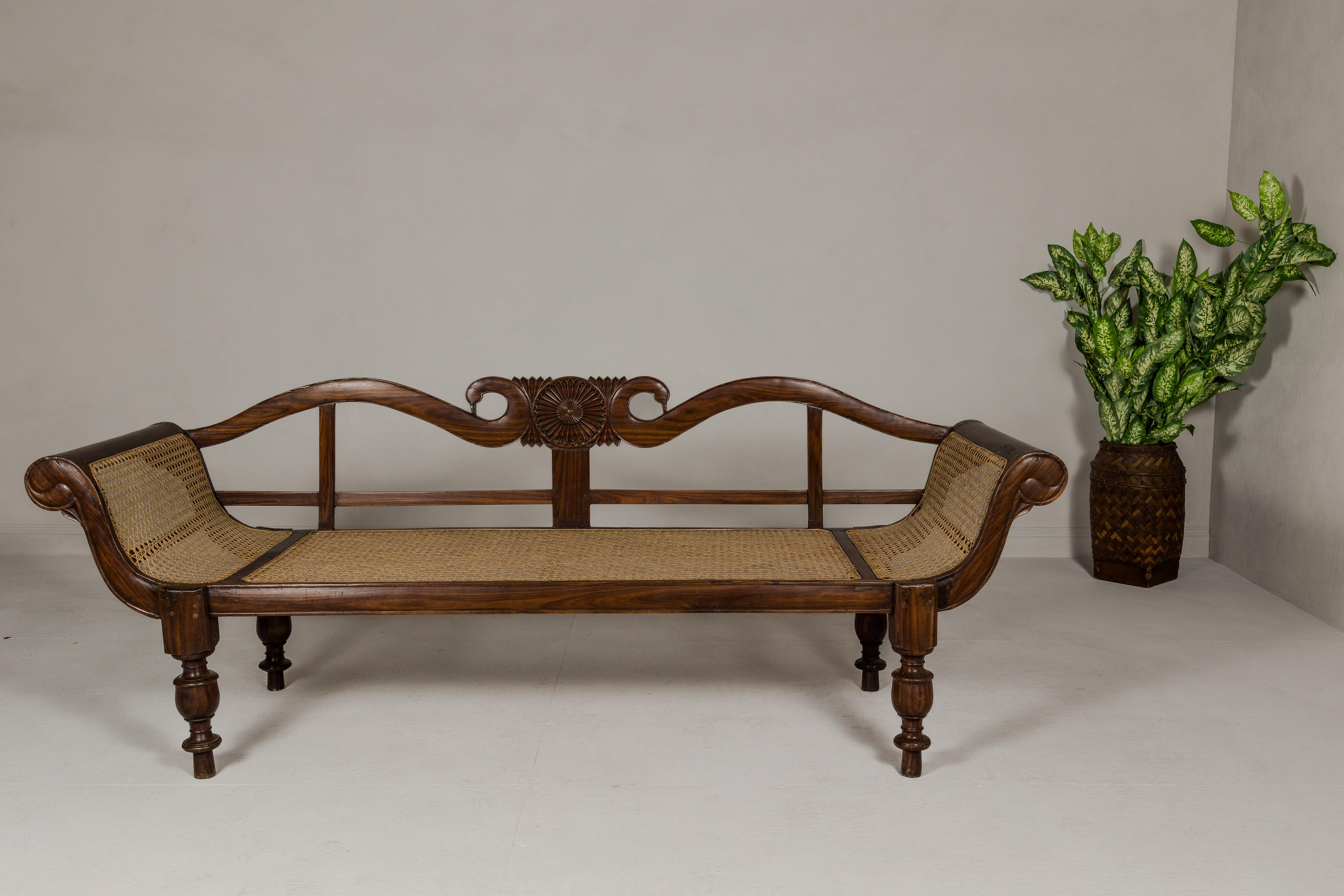 Southeast Asian British Colonial Carved and Cane Settee with Swan Neck Back and Scrolling Arms For Sale
