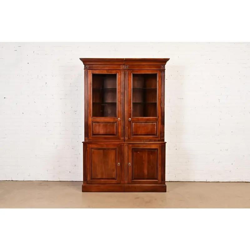 A gorgeous British Colonial or French Louis Philippe style four-piece lighted breakfront bookcase, display cabinet, or media cabinet

USA, Circa Late 20th Century

Carved cherry wood, with glass front doors and original brass hardware.

Measures:
