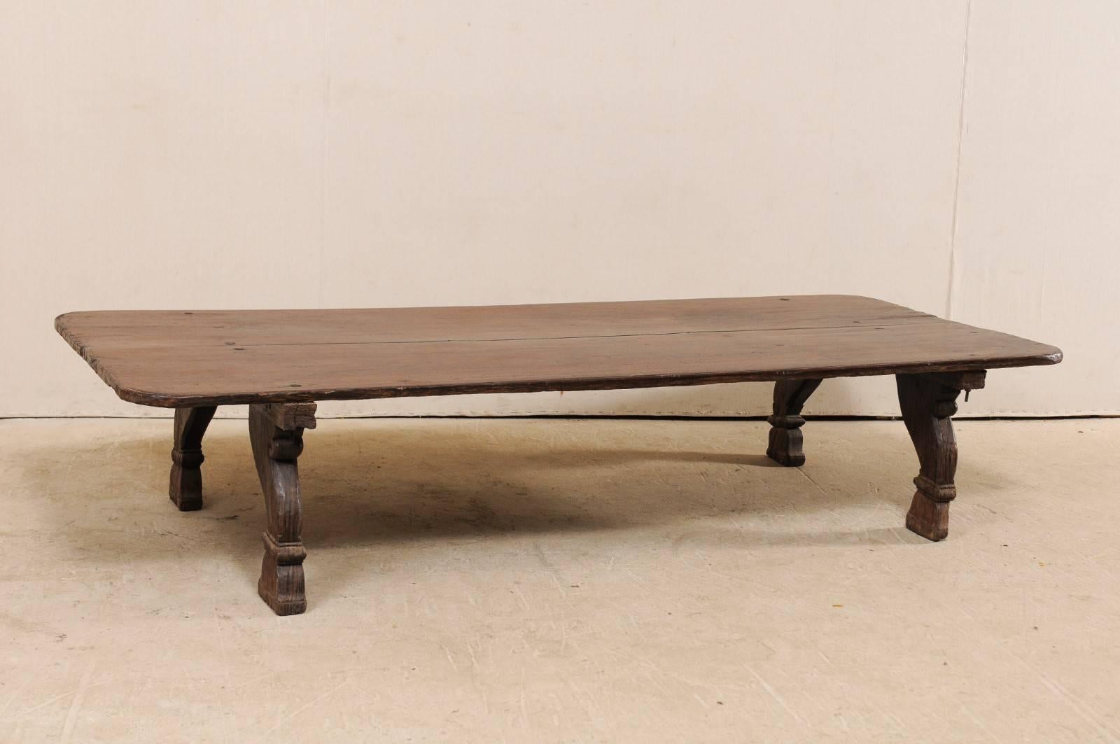 This midcentury British Colonial daybed from India makes for a wonderful modern-use coffee table. This vintage piece features a 7 ft long, rectangular-shaped top with curved edges, resting upon four nicely carved feet at each underside corner. This