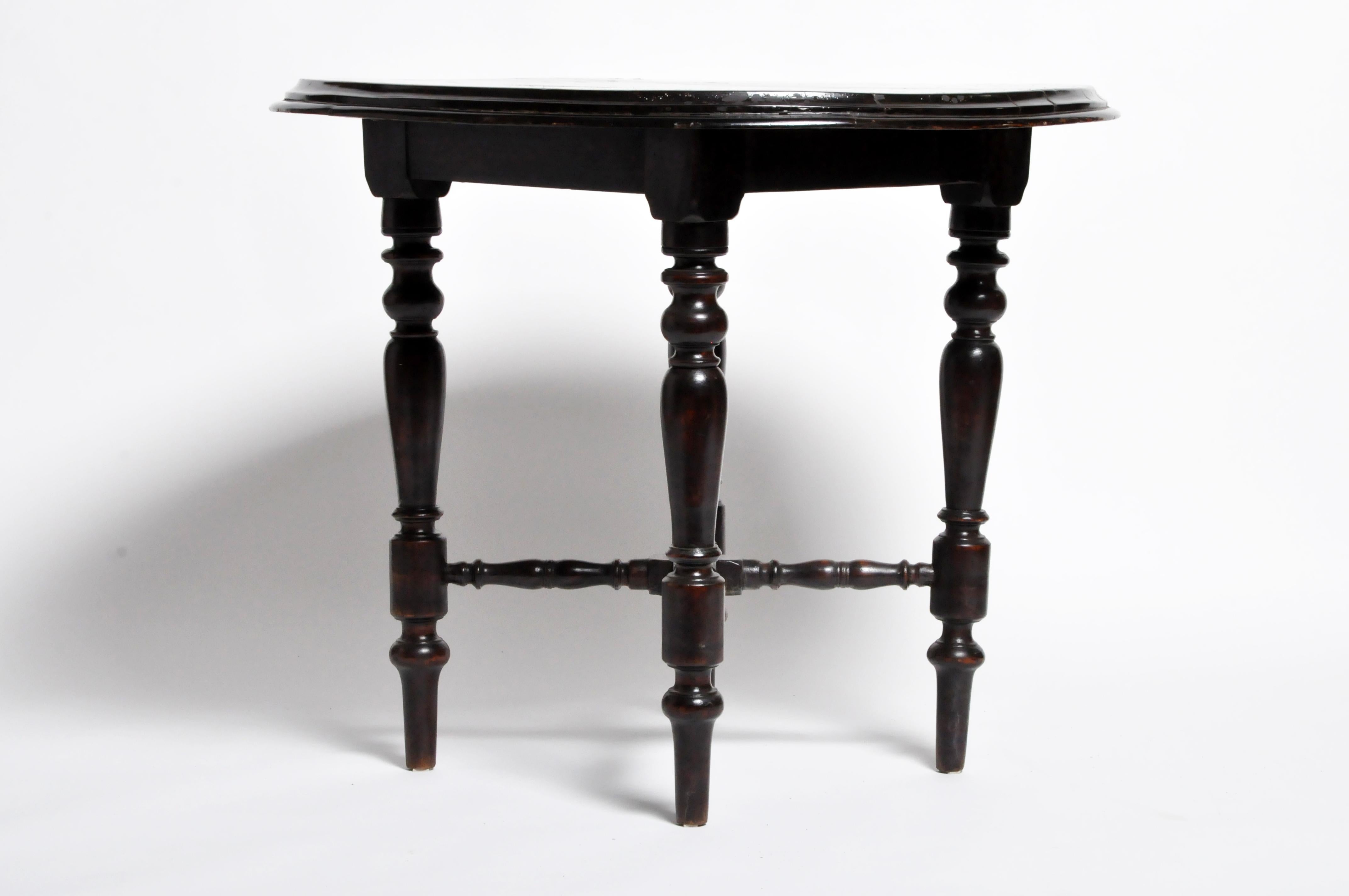 This handsome British Colonial round table was found in Northern Thailand but originally from Rangoon, Burma. It is made from teak wood with finished black lacquer and dates to about 1920 or earlier.  This is a good example of 