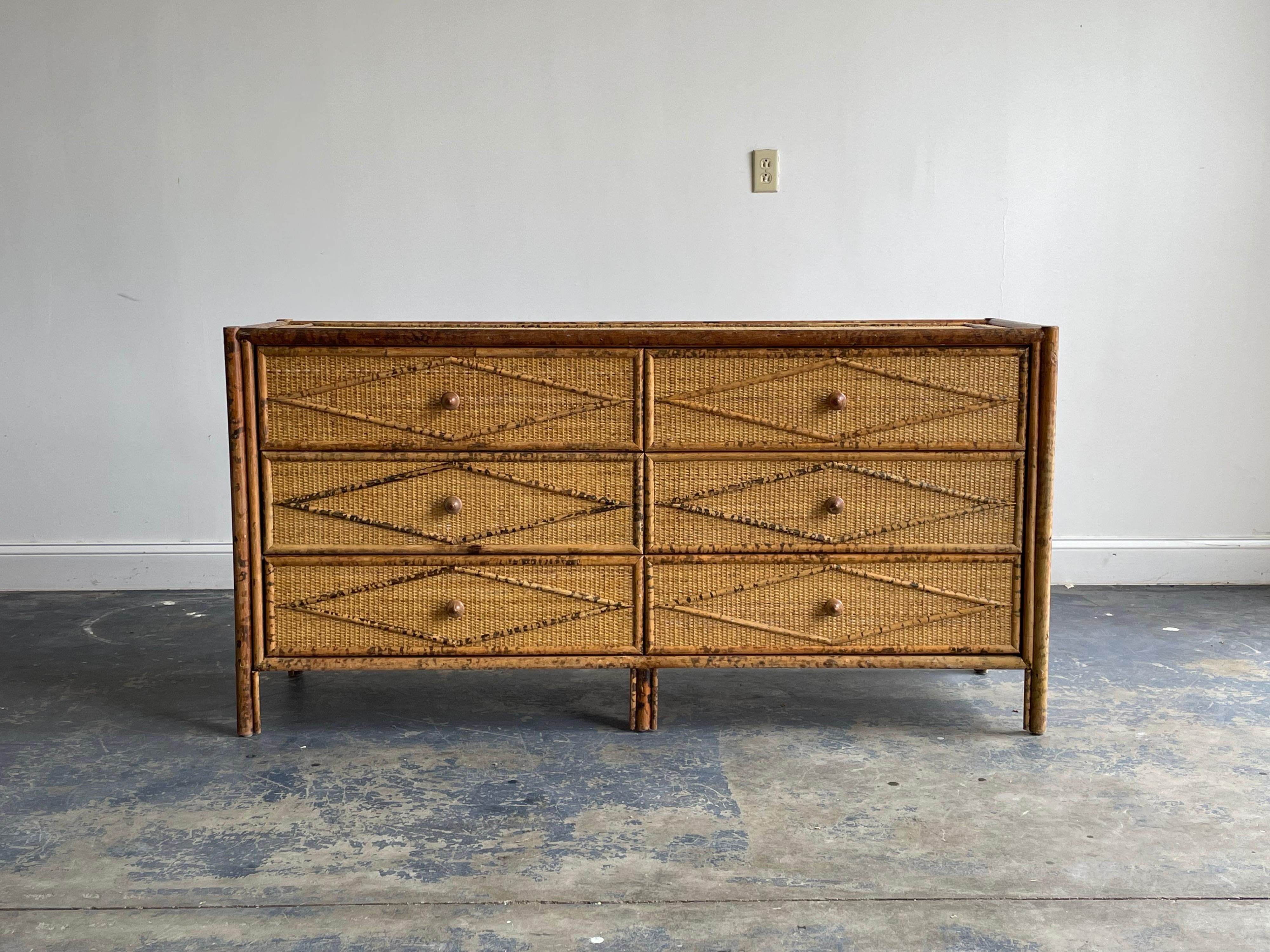 Vintage British colonial style dresser in bamboo and rattan. Six spacious drawers clad in rattan with a bamboo skeleton. Wonderful diamond pattern throughout.