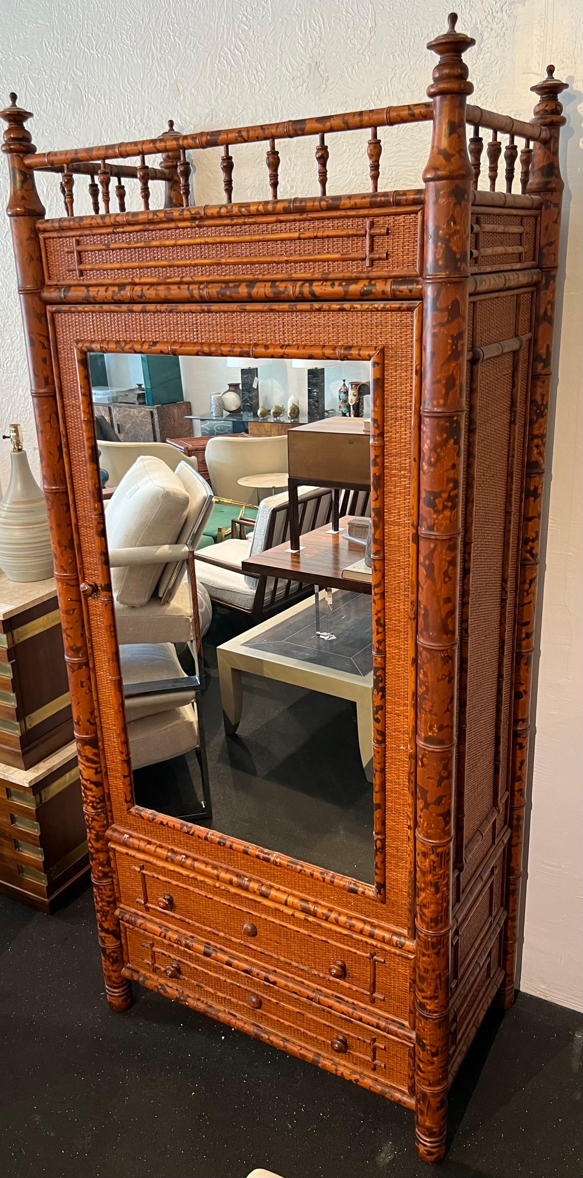 British colonial style burnt bamboo and cane armoire. Signed Bloomingdales. Wear to finish of cane and bamboo (please refer to photos). Additional photos available upon request.

Would work well in a variety of interiors such as modern, mid century