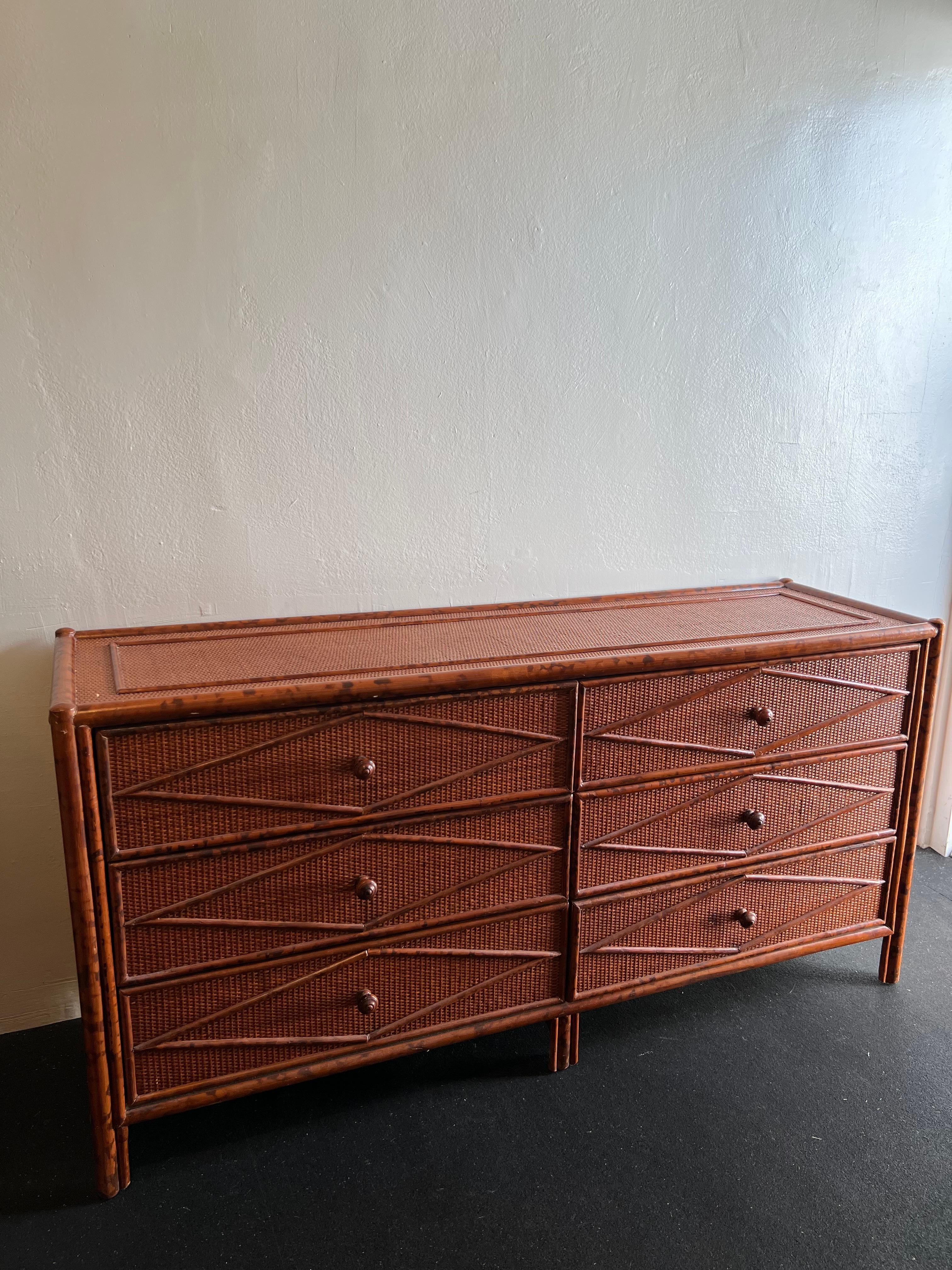 British colonial style burnt bamboo and cane dresser. Signed Bloomingdales. Slight wear to finish of cane (please refer to photos). Additional photos available upon request. 

Would work well in a variety of interiors such as modern, mid century