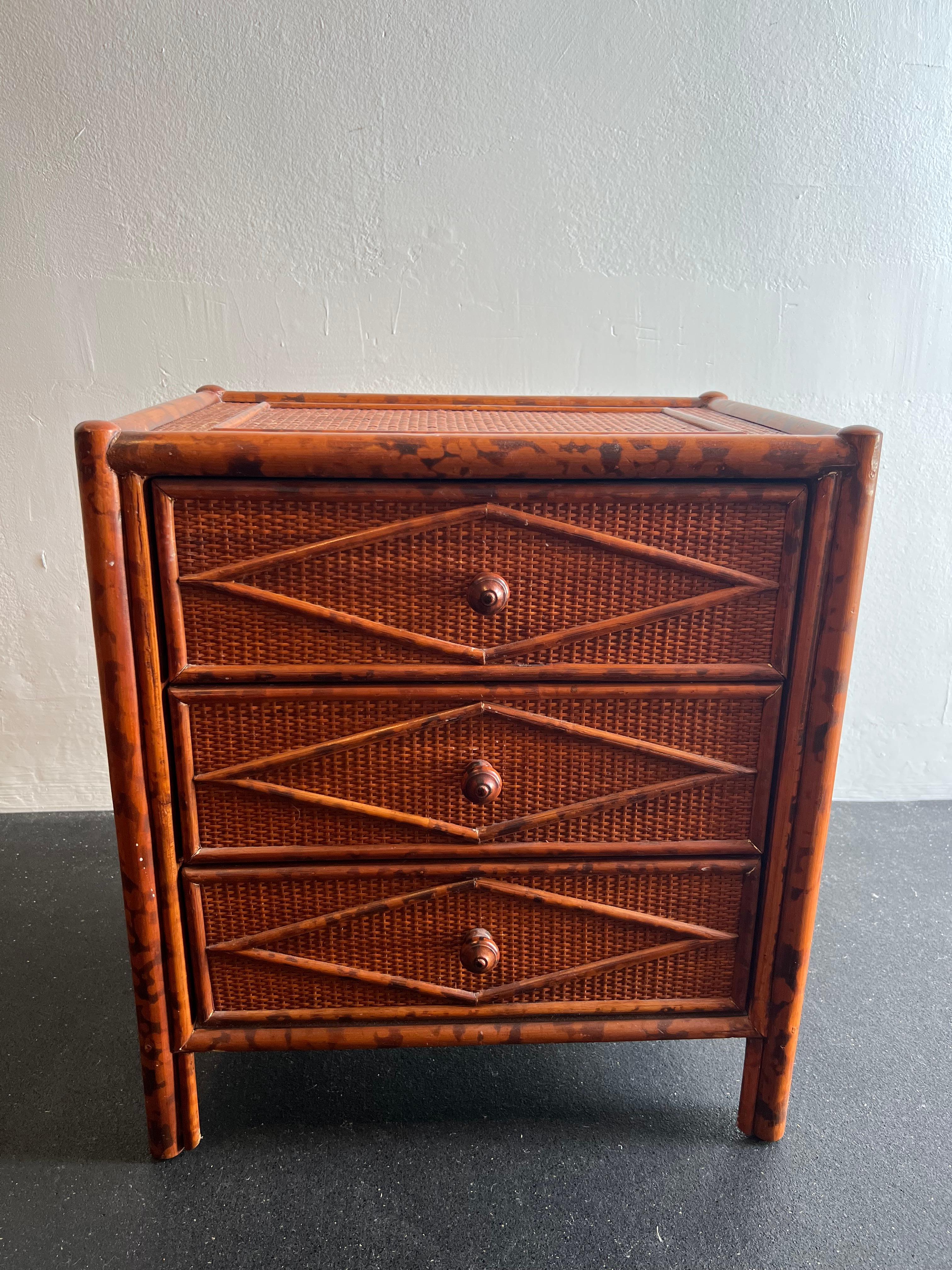 British colonial style burnt bamboo and cane nightstand. Signed Bloomingdales. Wear to finish of cane (please refer to photos). Additional photos available upon request.

Would work well in a variety of interiors such as modern, mid century modern,