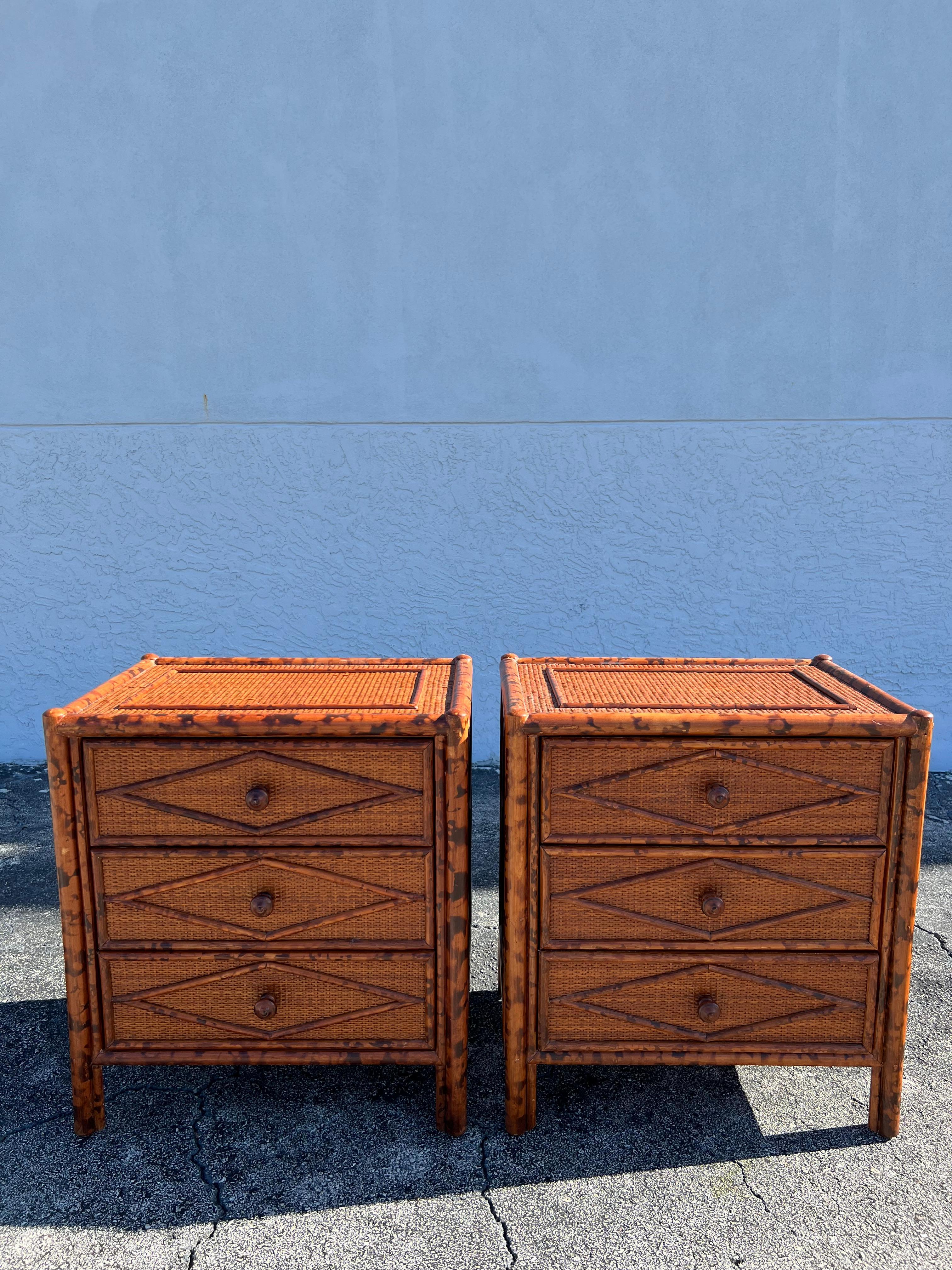 British colonial style burnt bamboo and cane pair of nightstands. Signed Bloomingdales. Slight wear to finish of cane (please refer to photos). Additional photos available upon request.

Would work well in a variety of interiors such as modern, mid